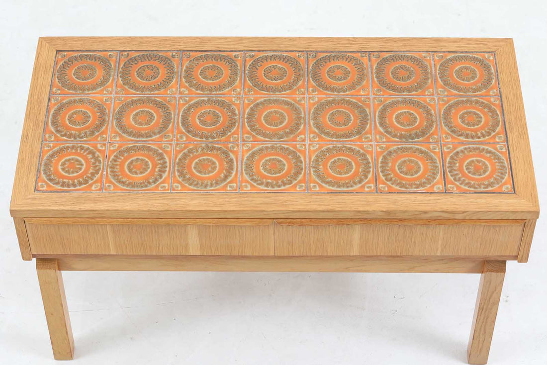 こちらは、北欧より買い付けたワイドチェストです。優れた品質のオーク材を本体に使用し、天板には淡いオレンジ色のタイルが施されており、デザインのアクセントとなっています。また、左右に取り付けられた細身の脚が、全体に洗練された印象を与えています。幅90cmのワイドサイズなので、ローボードやセンターテーブルとしてもお使いいただけます。