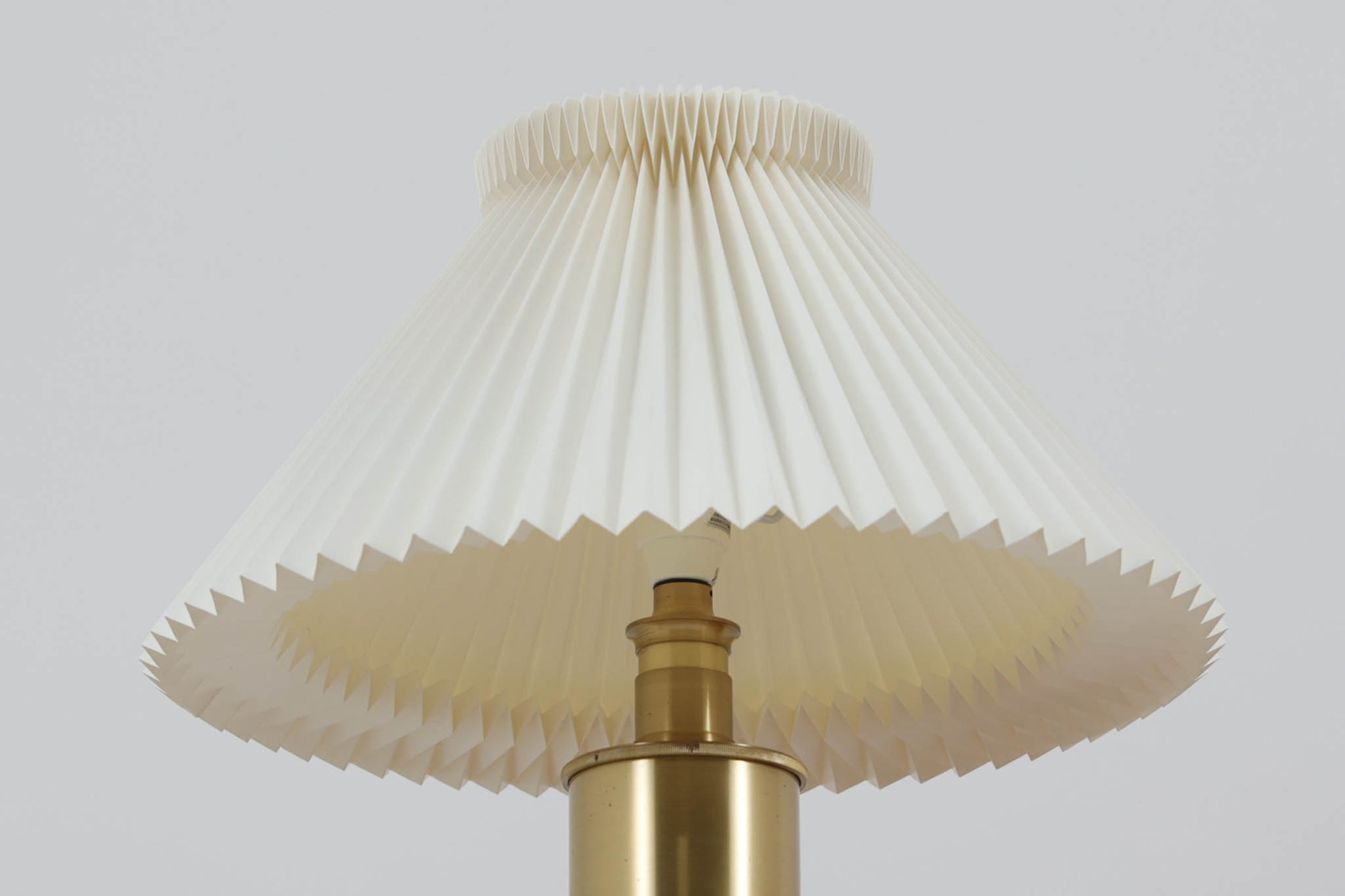 Gunnar Biilmann Petersenが1960年代にLe Klintのためにデザインしたこの「model 344 Telescope」は、独自の伸縮式高さ調節機能が特徴です。望遠鏡という名前は、ビルマン・ピーターセンがこのモデルに採用した、伸縮可能な高さ調節装置に由来しており、空間に応じた高さ調整が可能で、柔らかな光を提供します。さらに、この照明の真鍮製のベースが特に印象的で、重厚感と洗練された美しさを感じさせます。オリジナルのLe Klintシェードが付属しており、全体として北欧デザインの機能性と美しさが調和した貴重なアイテムです。