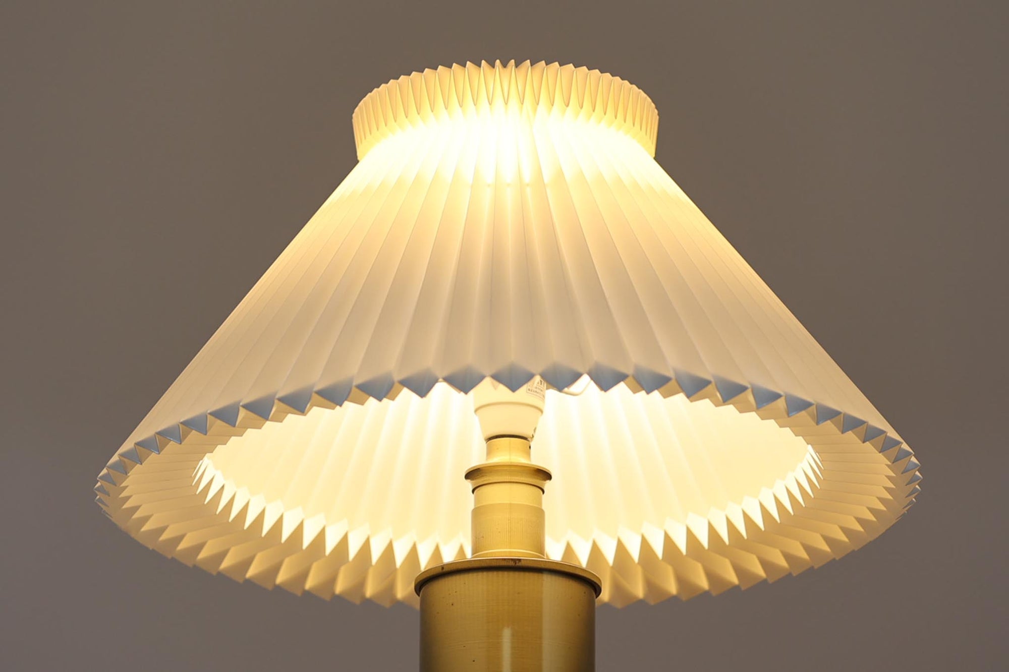 Gunnar Biilmann Petersenが1960年代にLe Klintのためにデザインしたこの「model 344 Telescope」は、独自の伸縮式高さ調節機能が特徴です。望遠鏡という名前は、ビルマン・ピーターセンがこのモデルに採用した、伸縮可能な高さ調節装置に由来しており、空間に応じた高さ調整が可能で、柔らかな光を提供します。さらに、この照明の真鍮製のベースが特に印象的で、重厚感と洗練された美しさを感じさせます。オリジナルのLe Klintシェードが付属しており、全体として北欧デザインの機能性と美しさが調和した貴重なアイテムです。