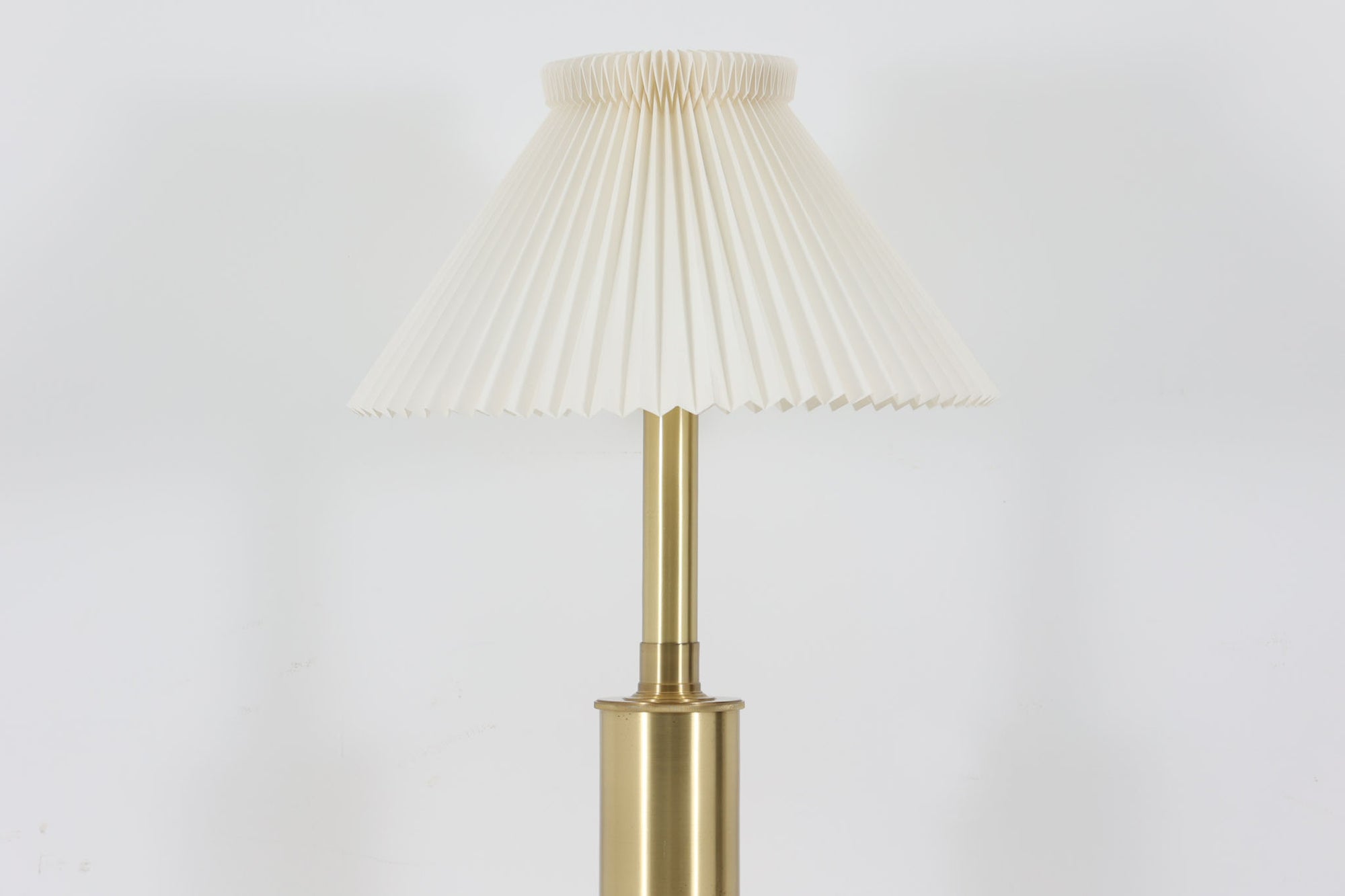 Gunnar Biilmann Petersenが1960年代にLe Klintのためにデザインしたこの「model 344 Telescope」は、独自の伸縮式高さ調節機能が特徴です。望遠鏡という名前は、ビルマン・ピーターセンがこのモデルに採用した、伸縮可能な高さ調節装置に由来しており、空間に応じた高さ調整が可能で、柔らかな光を提供します。さらに、この照明の真鍮製のベースが特に印象的で、重厚感と洗練された美しさを感じさせます。オリジナルのLe Klintシェードが付属しており、全体として北欧デザインの機能性と美しさが調和した貴重なアイテムです。