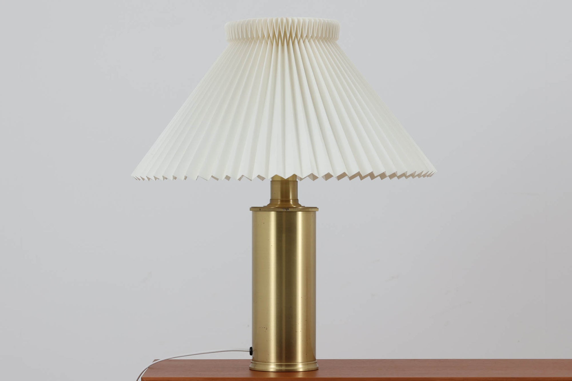 Gunnar Biilmann Petersenが1960年代にLe Klintのためにデザインしたこの「model 344 Telescope」は、独自の伸縮式高さ調節機能が特徴です。望遠鏡という名前は、ビルマン・ピーターセンがこのモデルに採用した、伸縮可能な高さ調節装置に由来しており、空間に応じた高さ調整が可能で、柔らかな光を提供します。さらに、この照明の真鍮製のベースが特に印象的で、重厚感と洗練された美しさを感じさせます。オリジナルのLe Klintシェードが付属しており、全体として北欧デザインの機能性と美しさが調和した貴重なアイテムです。