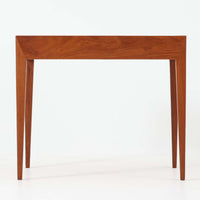 Severin Hansen Jr.によってデザインされ、Haslev社より製造されたこちらのサイドテーブルは、引き出しを備えた実用性と、シャープな面取りが際立つ意匠性を兼ね備えた一台です。チーク材の温もりある木目と、先細りのテーパードレッグが軽やかな印象を与え、繊細なジョイント仕上げからは北欧ビンテージ家具ならではの高いクラフトマンシップが感じられます。ベッドサイドやソファ横のアクセントとしてもおすすめです。