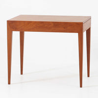 Severin Hansen Jr.によってデザインされ、Haslev社より製造されたこちらのサイドテーブルは、引き出しを備えた実用性と、シャープな面取りが際立つ意匠性を兼ね備えた一台です。チーク材の温もりある木目と、先細りのテーパードレッグが軽やかな印象を与え、繊細なジョイント仕上げからは北欧ビンテージ家具ならではの高いクラフトマンシップが感じられます。ベッドサイドやソファ横のアクセントとしてもおすすめです。