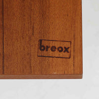 スウェーデンのBreox Moblerによるこちらのキッチンキャビネットは、温かみのあるチーク材を使用した北欧ビンテージ家具で、すっきりと直線的なフォルムと円形の木製取手が印象的な一台です。引き出し内には仕切り付きの収納も備え、カトラリーや小物の整理に便利です。扉内部は棚板付きで収納力にも優れ、中央の鍵付き扉はフラップ式でバースペースや食器収納としても活用できます。端正な佇まいと経年による木肌の深い色合いが空間に落ち着きを与える、実用性と存在感を兼ね備えた逸品です。