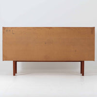 スウェーデンのBreox Moblerによるこちらのキッチンキャビネットは、温かみのあるチーク材を使用した北欧ビンテージ家具で、すっきりと直線的なフォルムと円形の木製取手が印象的な一台です。引き出し内には仕切り付きの収納も備え、カトラリーや小物の整理に便利です。扉内部は棚板付きで収納力にも優れ、中央の鍵付き扉はフラップ式でバースペースや食器収納としても活用できます。端正な佇まいと経年による木肌の深い色合いが空間に落ち着きを与える、実用性と存在感を兼ね備えた逸品です。