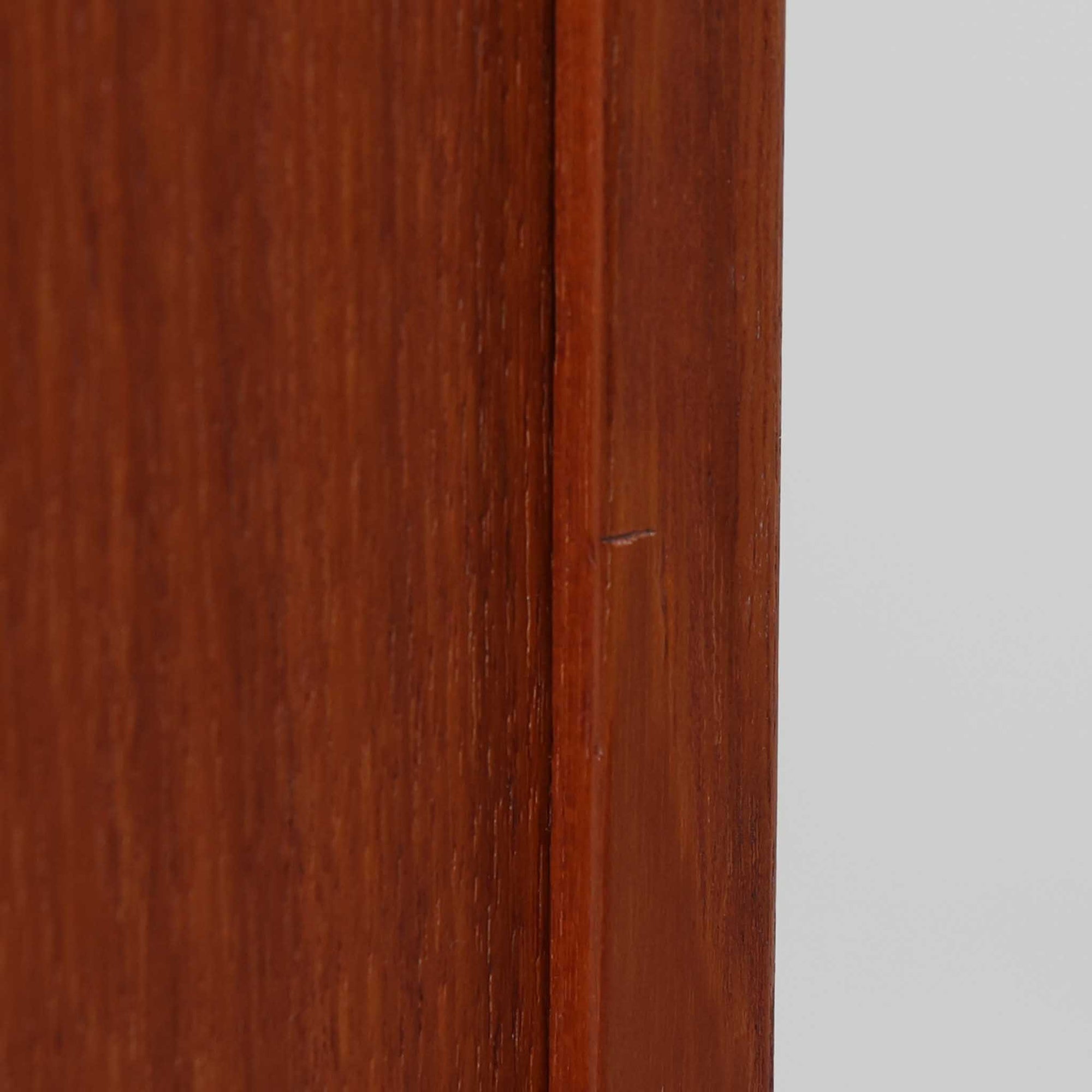 スウェーデンのBreox Moblerによるこちらのキッチンキャビネットは、温かみのあるチーク材を使用した北欧ビンテージ家具で、すっきりと直線的なフォルムと円形の木製取手が印象的な一台です。引き出し内には仕切り付きの収納も備え、カトラリーや小物の整理に便利です。扉内部は棚板付きで収納力にも優れ、中央の鍵付き扉はフラップ式でバースペースや食器収納としても活用できます。端正な佇まいと経年による木肌の深い色合いが空間に落ち着きを与える、実用性と存在感を兼ね備えた逸品です。