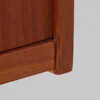 スウェーデンのBreox Moblerによるこちらのキッチンキャビネットは、温かみのあるチーク材を使用した北欧ビンテージ家具で、すっきりと直線的なフォルムと円形の木製取手が印象的な一台です。引き出し内には仕切り付きの収納も備え、カトラリーや小物の整理に便利です。扉内部は棚板付きで収納力にも優れ、中央の鍵付き扉はフラップ式でバースペースや食器収納としても活用できます。端正な佇まいと経年による木肌の深い色合いが空間に落ち着きを与える、実用性と存在感を兼ね備えた逸品です。