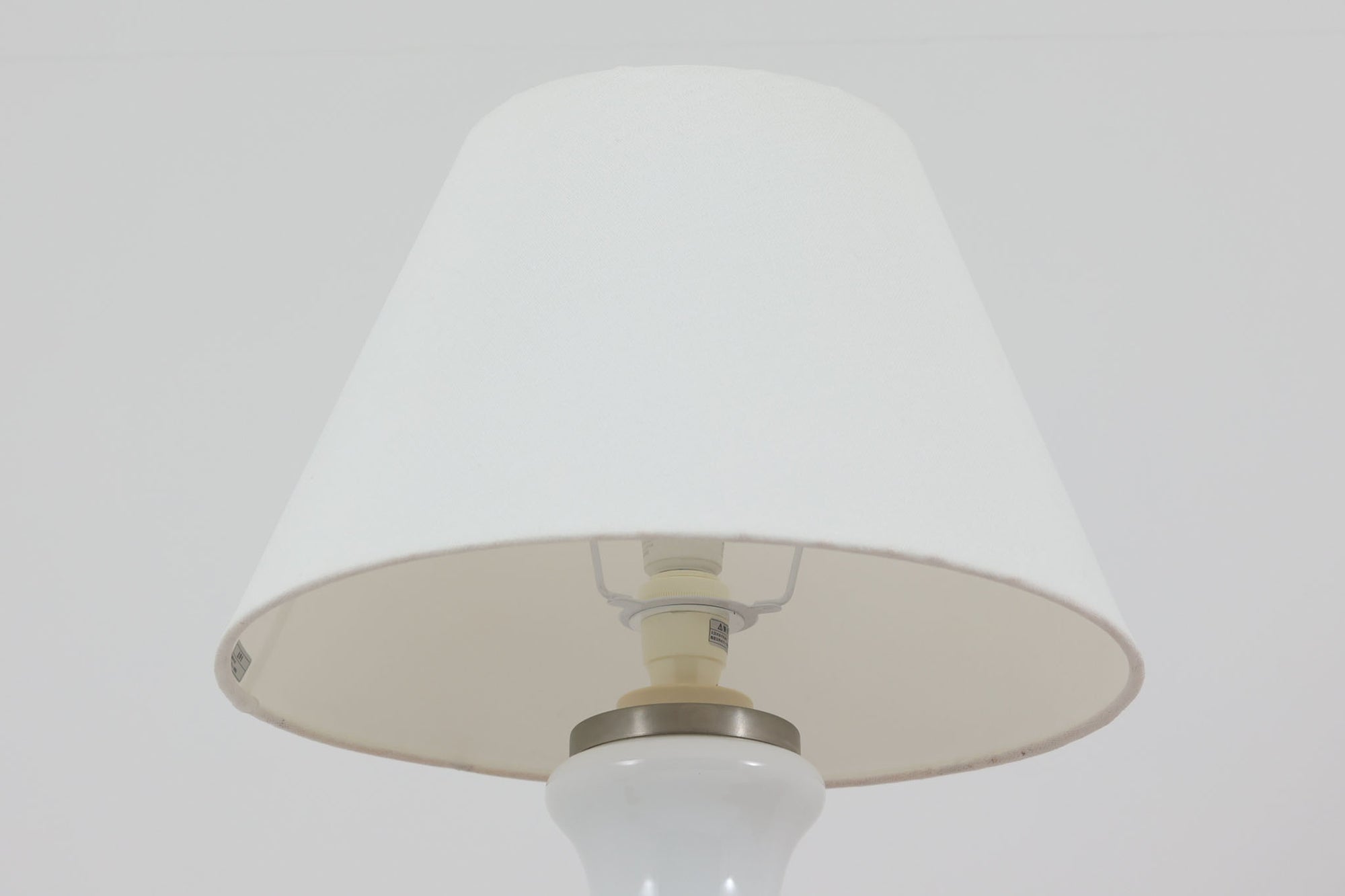 著名なデザイナー、Sidse Werner（シセ・ヴェルナー）による「BIBLIOTEK」のテーブルランプです。ペンダントランプはよく見かけますが、テーブルランプは非常に珍しいモデルです。ホルムガードならではの厚みのある高品質なガラスを使用しており、点灯するとシェードを通して柔らかな温かみのある光が広がり、空間を優雅に照らします。高さ64cmの大型サイズで存在感があり、リビングや書斎、ベッドサイドなど、あらゆるインテリアに美しく調和します。