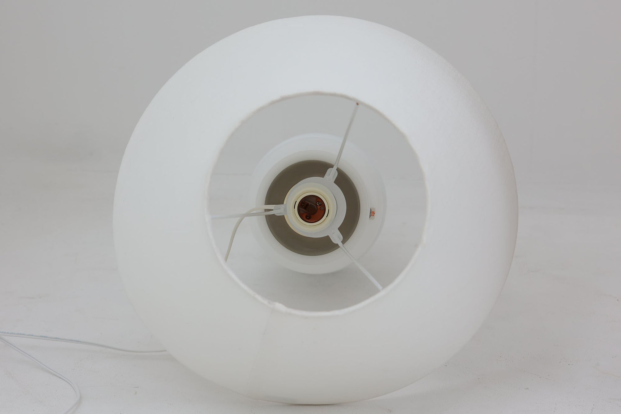 著名なデザイナー、Sidse Werner（シセ・ヴェルナー）による「BIBLIOTEK」のテーブルランプです。ペンダントランプはよく見かけますが、テーブルランプは非常に珍しいモデルです。ホルムガードならではの厚みのある高品質なガラスを使用しており、点灯するとシェードを通して柔らかな温かみのある光が広がり、空間を優雅に照らします。高さ64cmの大型サイズで存在感があり、リビングや書斎、ベッドサイドなど、あらゆるインテリアに美しく調和します。