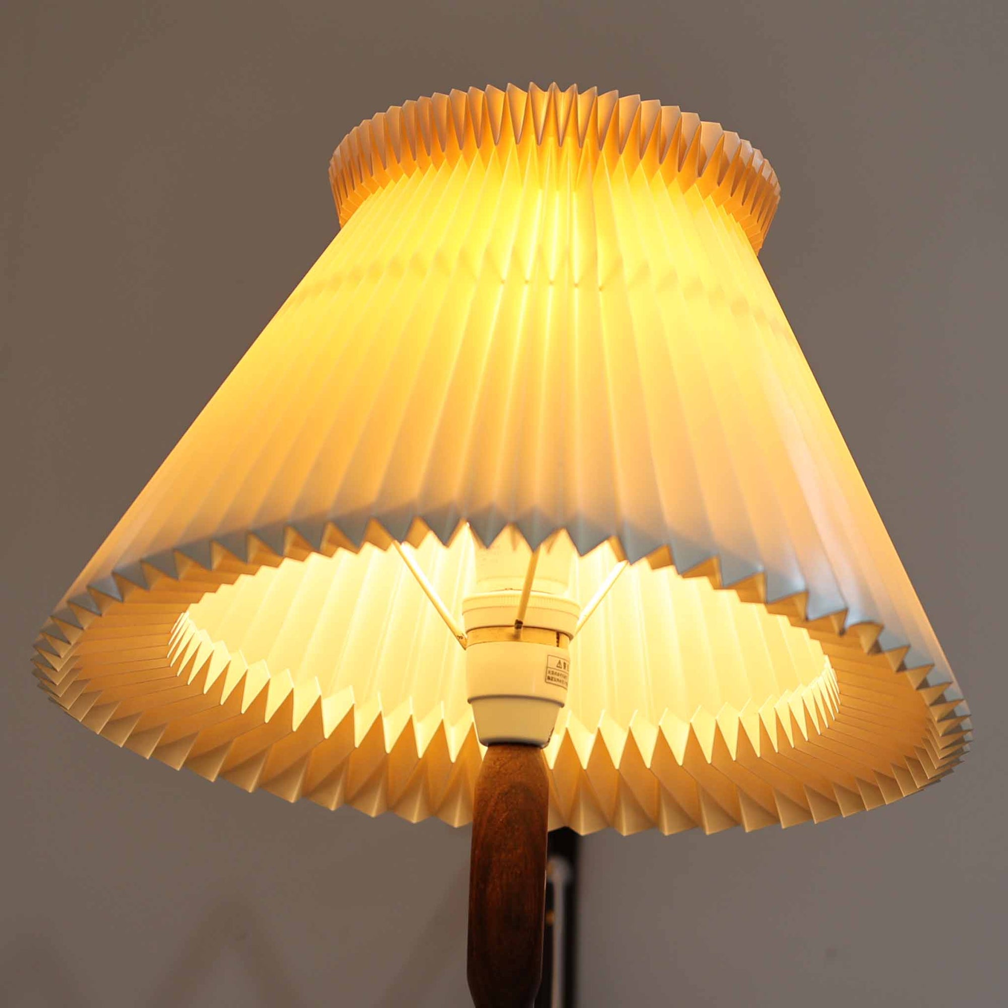 Erik Hansen（エリック・ハンセン）がデザインし、Le Klint（レ・クリント）より発表されたブラケットランプModel 332です。温かみのあるローズウッド材のアームと、職人技によるプリーツシェードの組み合わせが美しく、北欧らしい柔らかな光を演出します。アコーディオン式のアームは伸縮可能で、ベッドサイドやリビングの読書灯としても最適です。経年により味わいを増した木部とオリジナルシェードが、ビンテージならではの存在感を放ちます。ローズウッド材での展開はビンテージ品でのみ入手可能で、現行品には存在しない希少な一品です。