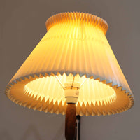 Erik Hansen（エリック・ハンセン）がデザインし、Le Klint（レ・クリント）より発表されたブラケットランプModel 332です。温かみのあるローズウッド材のアームと、職人技によるプリーツシェードの組み合わせが美しく、北欧らしい柔らかな光を演出します。アコーディオン式のアームは伸縮可能で、ベッドサイドやリビングの読書灯としても最適です。経年により味わいを増した木部とオリジナルシェードが、ビンテージならではの存在感を放ちます。ローズウッド材での展開はビンテージ品でのみ入手可能で、現行品には存在しない希少な一品です。