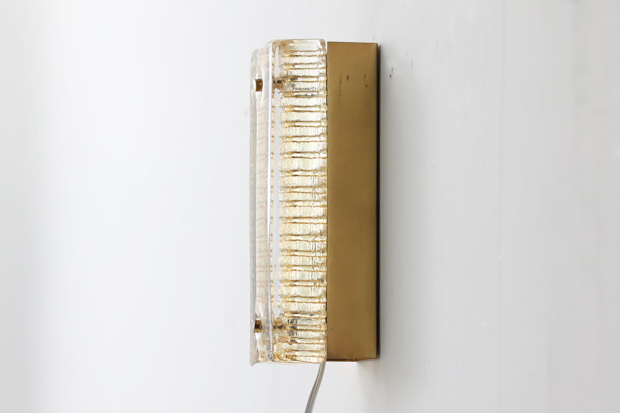 ODRECOはデンマークの照明ブランドで、1950〜1970年代に洗練されたデザインの照明器具を生み出しました。このウォールランプはアンバー色のガラスが特徴で、灯りを灯すと柔らかな光が空間を美しく照らします。落ち着いた色合いが温かみを感じさせ、どんなインテリアにも調和するシンプルでありながら存在感のあるデザインです。リビングや寝室、廊下など、さまざまな空間にぴったりです。