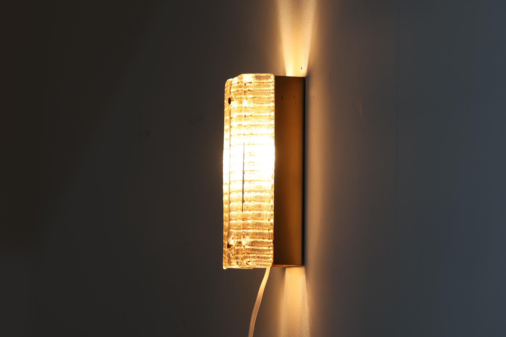 ODRECOはデンマークの照明ブランドで、1950〜1970年代に洗練されたデザインの照明器具を生み出しました。このウォールランプはアンバー色のガラスが特徴で、灯りを灯すと柔らかな光が空間を美しく照らします。落ち着いた色合いが温かみを感じさせ、どんなインテリアにも調和するシンプルでありながら存在感のあるデザインです。リビングや寝室、廊下など、さまざまな空間にぴったりです。