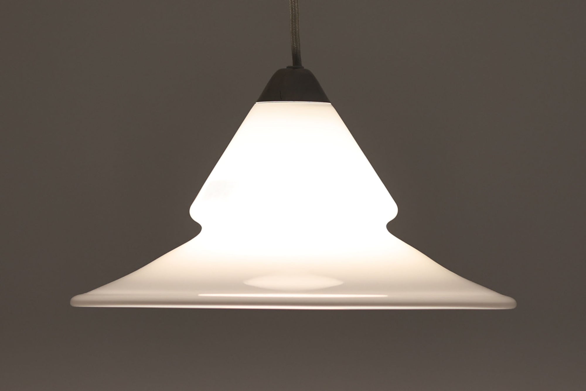 こちらは北欧で買い付けたペンダントライト「Opus」です。デザイナーのTorben Jorgensenンによって手掛けられたもので、厚みのある乳白色のガラスとアルミ製トップの組み合わせが特徴的です。現地でも数が少なく珍しいモデルです。シェードが下方に広がるデザインは、温かみのあるダイニングスペースを演出してくれそうです。