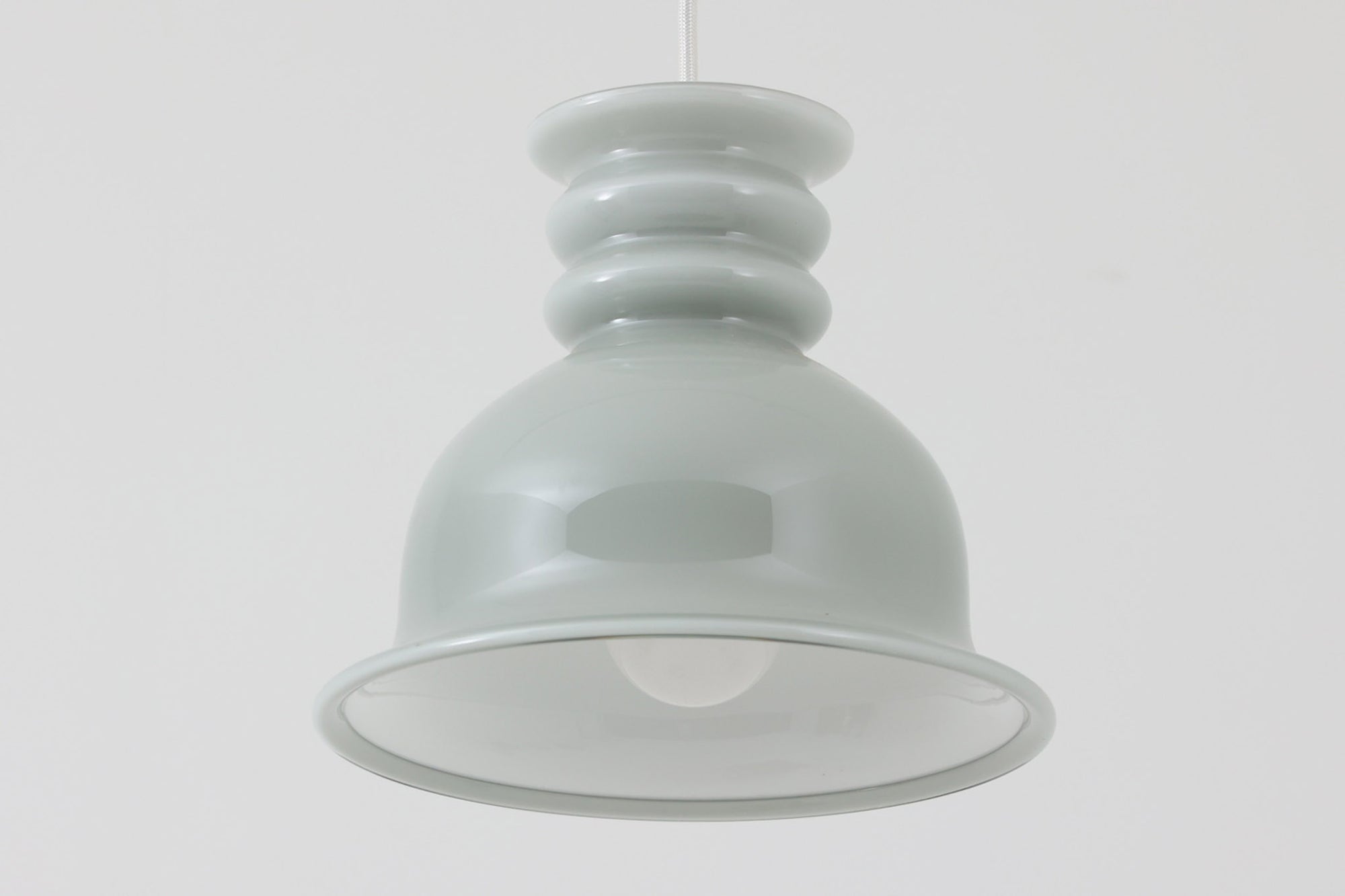 北欧より買い付けた、Holmgaard社製(現Royal Copenhagen)ビンテージランプです。「Kropendel」シリーズです。シリーズ名の「Kropendel」は、「命の源」を意味し、まさにその名の通り、空間に生命力を吹き込むような魅力を持っています。このシリーズは、Holmegaardならではの厚みのある高品質なオパールガラスが使用されており、職人によってひとつひとつ手作業で仕上げられています。光を受けて美しく反射するガラスの質感と、シンプルでありながら存在感のあるデザインが、どんな空間にも調和します。