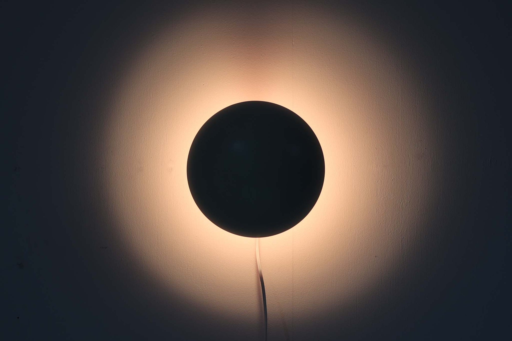 もともとへニングセンが自宅寝室のためにデザインし、1961年に発表したウォールライトで、温かみのある光を生むためシェード内面はローズ色に塗装されています。壁面でソフトな間接照明が得られ、広がり感のある空間をつくりだします。シェードが約60度可動するため、ベッドやソファーサイドの読書灯としても適しています。 