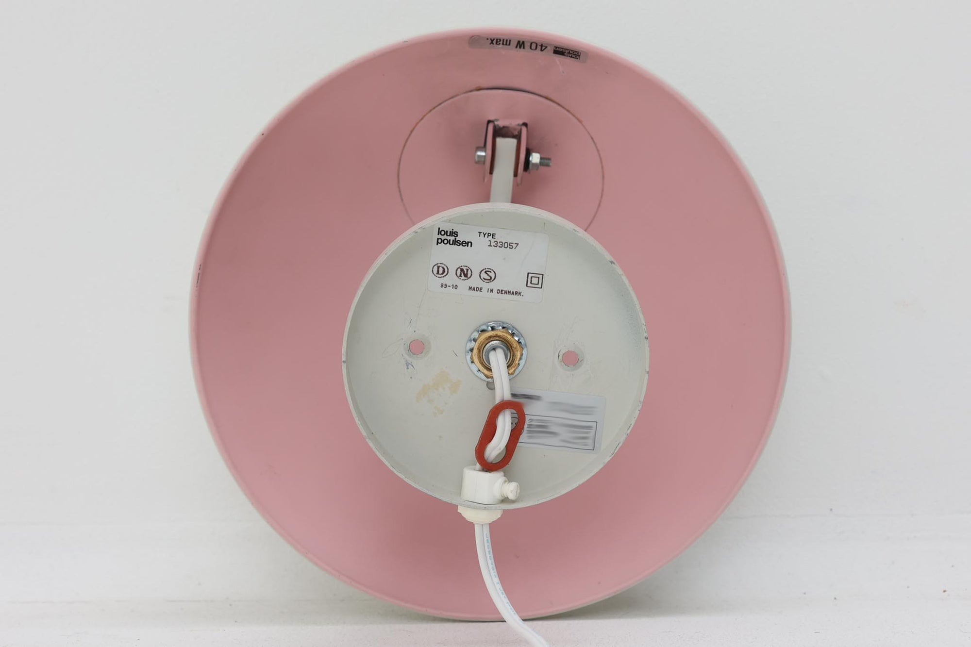 もともとへニングセンが自宅寝室のためにデザインし、1961年に発表したウォールライトで、温かみのある光を生むためシェード内面はローズ色に塗装されています。壁面でソフトな間接照明が得られ、広がり感のある空間をつくりだします。シェードが約60度可動するため、ベッドやソファーサイドの読書灯としても適しています。 