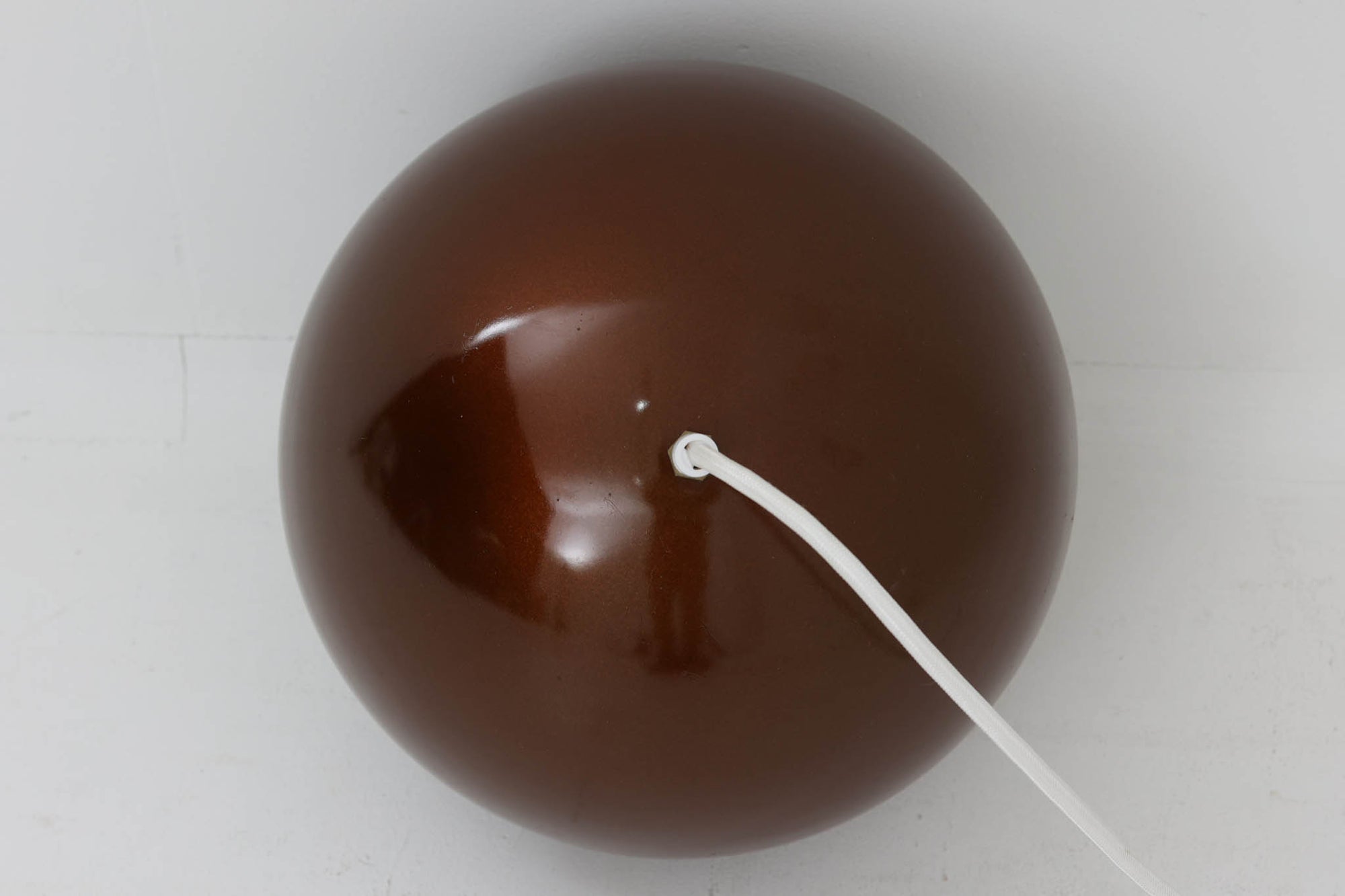こちらは北欧より買い付けたボール型ペンダントライトです。1959年にVerner Pantonがデザインした「Topan」に影響を受け、1960年代にはスペースエイジデザインの照明が各メーカーから次々と発売されました。こちらの照明もその時代の象徴的なデザインの一つで、シンプルでありながらも洗練された美しさを感じさせます。