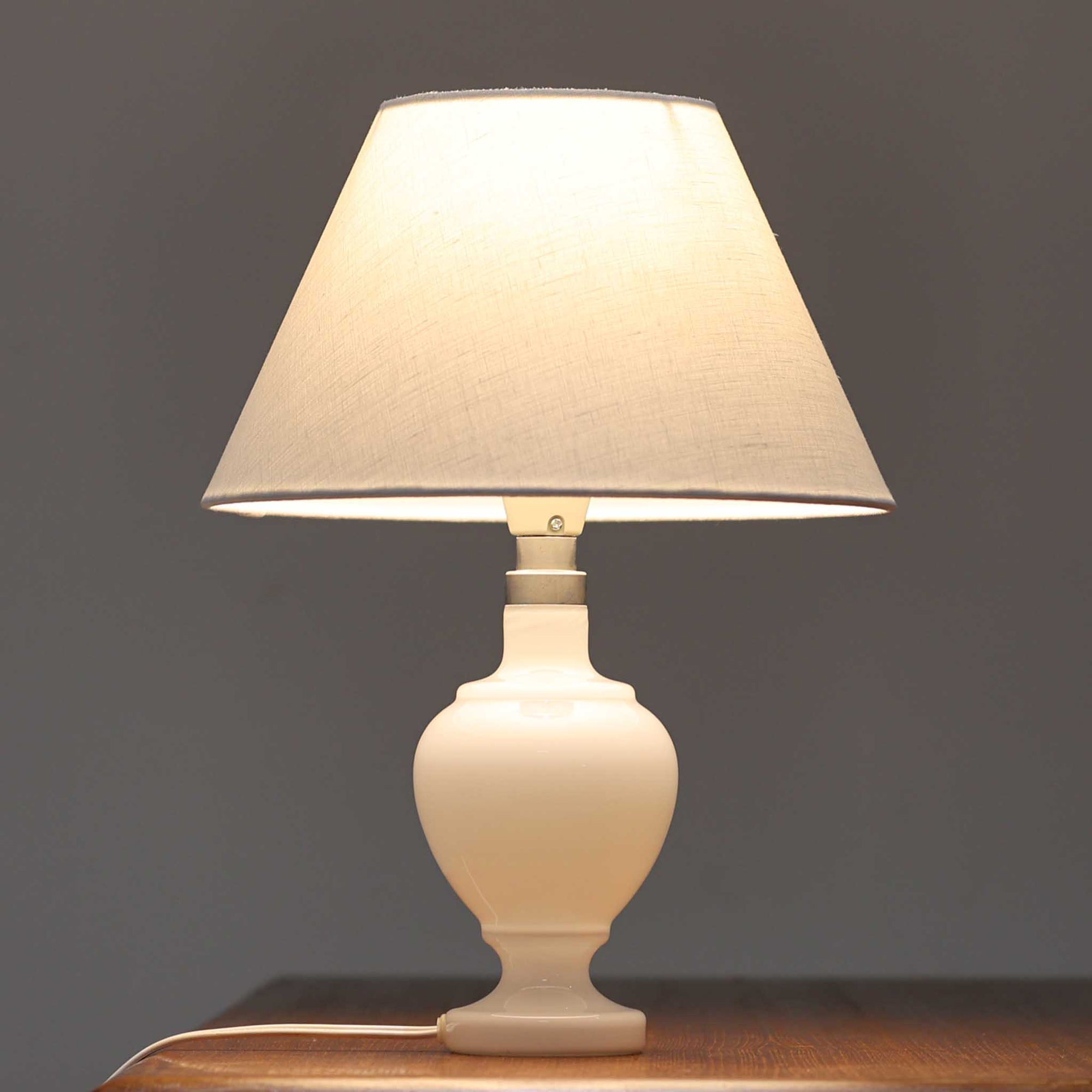 Anne Grethe von Halling-KochがRoyal Copenhagenより発表したモデル「Roma」のテーブルランプです。ガラスベースの柔らかな曲線が美しく、シェードにはリネンが用いられており、点灯時には温かみのある光が空間を優しく包み込みます。高さ34cmと程よいサイズ感で、ベッドサイドやリビングのアクセント照明としても最適です。デンマーク製ならではの洗練された造形と、経年を重ねたビンテージならではの趣が調和した一品です。