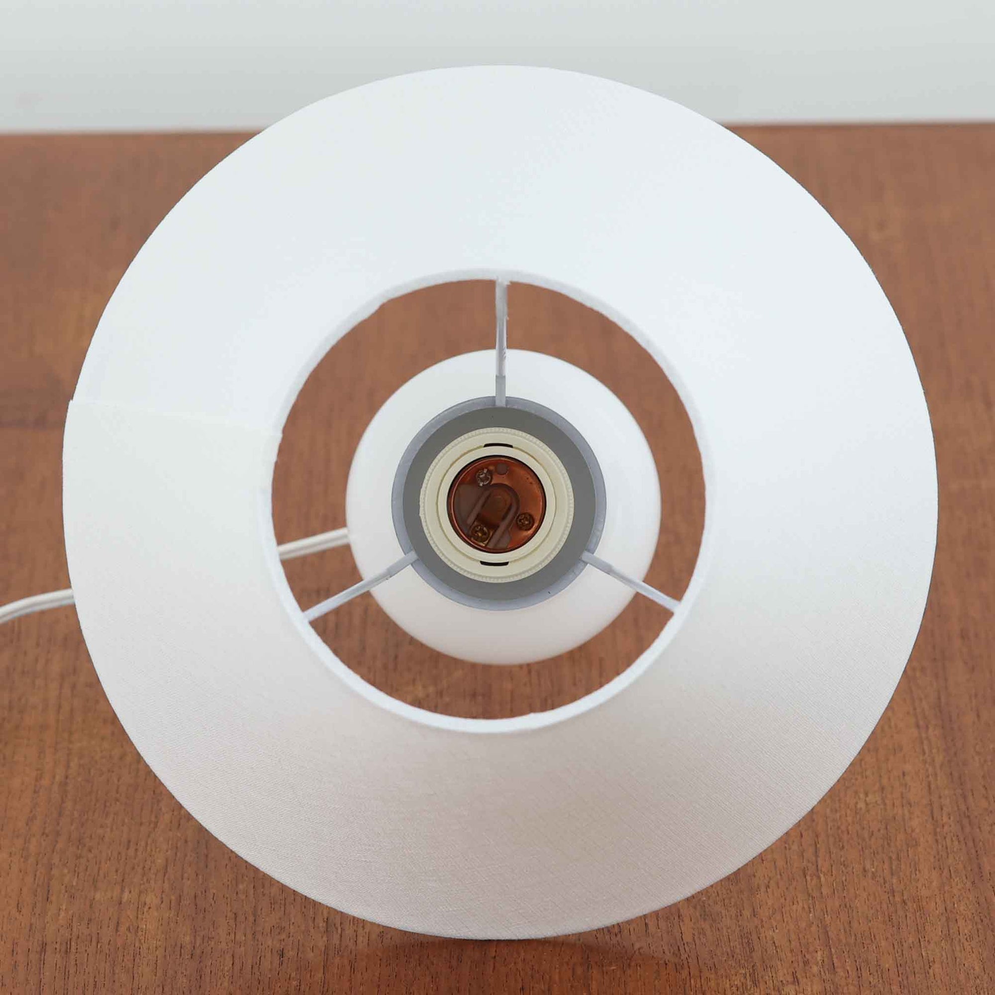 Anne Grethe von Halling-KochがRoyal Copenhagenより発表したモデル「Roma」のテーブルランプです。ガラスベースの柔らかな曲線が美しく、シェードにはリネンが用いられており、点灯時には温かみのある光が空間を優しく包み込みます。高さ34cmと程よいサイズ感で、ベッドサイドやリビングのアクセント照明としても最適です。デンマーク製ならではの洗練された造形と、経年を重ねたビンテージならではの趣が調和した一品です。