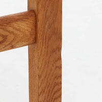Hans J. Wegner（ハンス・J・ウェグナー）がデザインし、Getama（ゲタマ）が製造を手掛けたGE151アームチェアです。オーク材による直線的で端正なフレームに、ゆるやかにカーブした背もたれと座面を組み合わせた、軽快で機能的な佇まいが魅力。幅のあるアームは木の質感を存分に感じられ、長年の使用による風合いもビンテージならではの味わいです。ダイニングや書斎のほか、ゆったりと腰掛けるラウンジチェアとしても取り入れやすい一脚です。