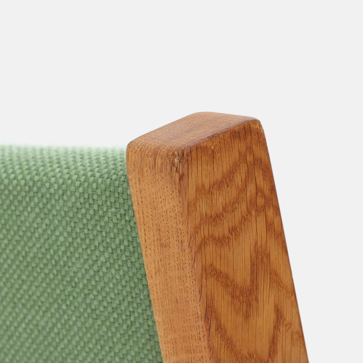Hans J. Wegner（ハンス・J・ウェグナー）がデザインし、Getama（ゲタマ）が製造を手掛けたGE151アームチェアです。オーク材による直線的で端正なフレームに、ゆるやかにカーブした背もたれと座面を組み合わせた、軽快で機能的な佇まいが魅力。幅のあるアームは木の質感を存分に感じられ、長年の使用による風合いもビンテージならではの味わいです。ダイニングや書斎のほか、ゆったりと腰掛けるラウンジチェアとしても取り入れやすい一脚です。