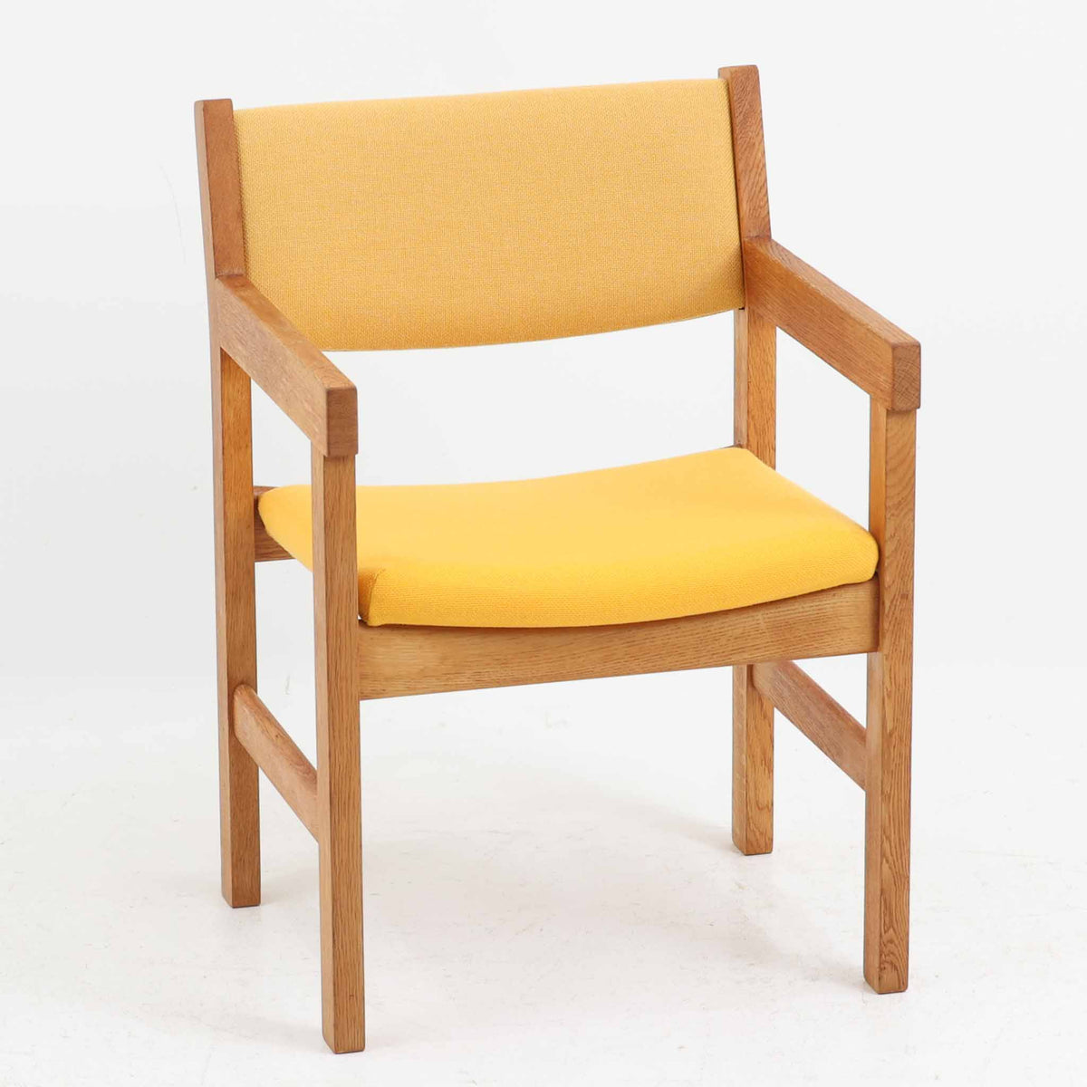 Hans J. Wegner（ハンス・J・ウェグナー）がデザインし、Getama（ゲタマ）が製造を手掛けたGE151アームチェアです。オーク材による直線的で端正なフレームに、ゆるやかにカーブした背もたれと座面を組み合わせた、軽快で機能的な佇まいが魅力。幅のあるアームは木の質感を存分に感じられ、長年の使用による風合いもビンテージならではの味わいです。ダイニングや書斎のほか、ゆったりと腰掛けるラウンジチェアとしても取り入れやすい一脚です。