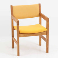 Hans J. Wegner（ハンス・J・ウェグナー）がデザインし、Getama（ゲタマ）が製造を手掛けたGE151アームチェアです。オーク材による直線的で端正なフレームに、ゆるやかにカーブした背もたれと座面を組み合わせた、軽快で機能的な佇まいが魅力。幅のあるアームは木の質感を存分に感じられ、長年の使用による風合いもビンテージならではの味わいです。ダイニングや書斎のほか、ゆったりと腰掛けるラウンジチェアとしても取り入れやすい一脚です。