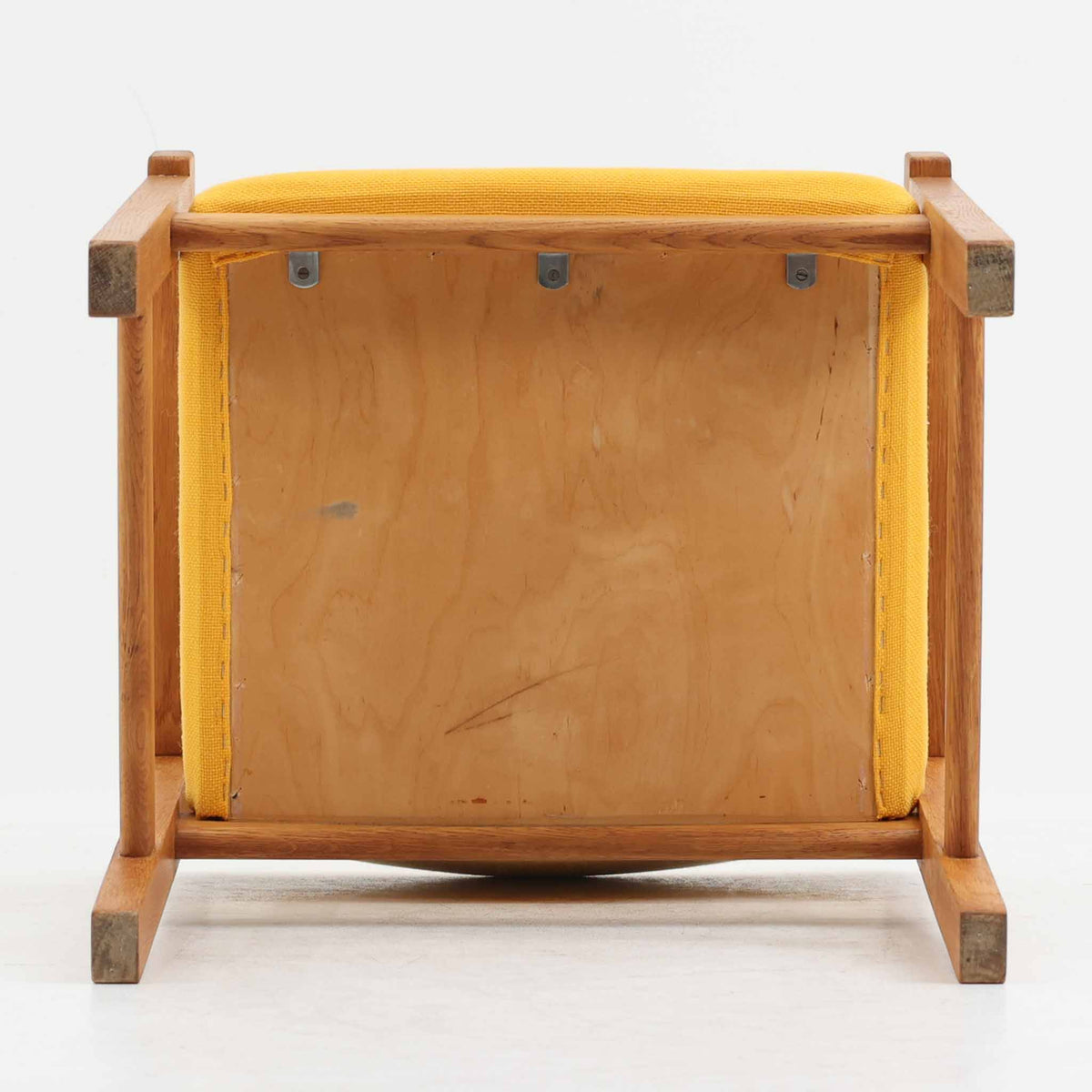Hans J. Wegner（ハンス・J・ウェグナー）がデザインし、Getama（ゲタマ）が製造を手掛けたGE151アームチェアです。オーク材による直線的で端正なフレームに、ゆるやかにカーブした背もたれと座面を組み合わせた、軽快で機能的な佇まいが魅力。幅のあるアームは木の質感を存分に感じられ、長年の使用による風合いもビンテージならではの味わいです。ダイニングや書斎のほか、ゆったりと腰掛けるラウンジチェアとしても取り入れやすい一脚です。