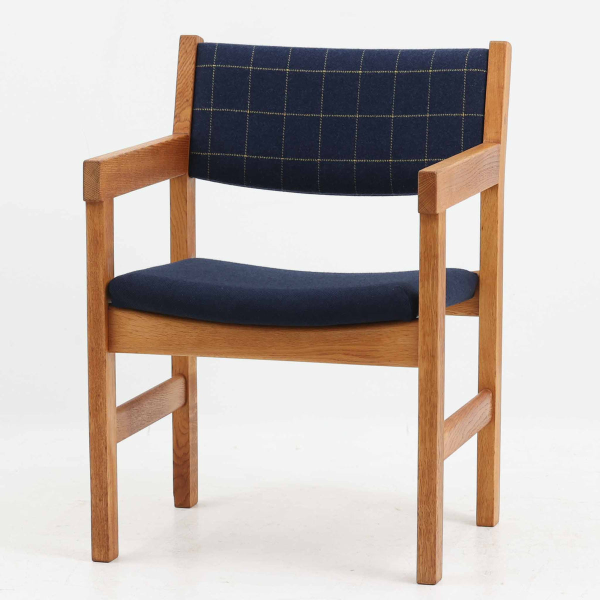 Hans J. Wegner（ハンス・J・ウェグナー）がデザインし、Getama（ゲタマ）が製造を手掛けたGE151アームチェアです。オーク材による直線的で端正なフレームに、ゆるやかにカーブした背もたれと座面を組み合わせた、軽快で機能的な佇まいが魅力。幅のあるアームは木の質感を存分に感じられ、長年の使用による風合いもビンテージならではの味わいです。ダイニングや書斎のほか、ゆったりと腰掛けるラウンジチェアとしても取り入れやすい一脚です。