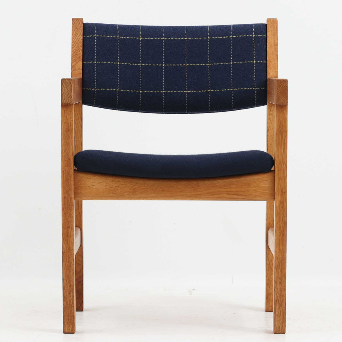 Hans J. Wegner（ハンス・J・ウェグナー）がデザインし、Getama（ゲタマ）が製造を手掛けたGE151アームチェアです。オーク材による直線的で端正なフレームに、ゆるやかにカーブした背もたれと座面を組み合わせた、軽快で機能的な佇まいが魅力。幅のあるアームは木の質感を存分に感じられ、長年の使用による風合いもビンテージならではの味わいです。ダイニングや書斎のほか、ゆったりと腰掛けるラウンジチェアとしても取り入れやすい一脚です。