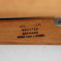 Hans J. Wegner（ハンス・J・ウェグナー）がデザインし、Getama（ゲタマ）が製造を手掛けたGE151アームチェアです。オーク材による直線的で端正なフレームに、ゆるやかにカーブした背もたれと座面を組み合わせた、軽快で機能的な佇まいが魅力。幅のあるアームは木の質感を存分に感じられ、長年の使用による風合いもビンテージならではの味わいです。ダイニングや書斎のほか、ゆったりと腰掛けるラウンジチェアとしても取り入れやすい一脚です。