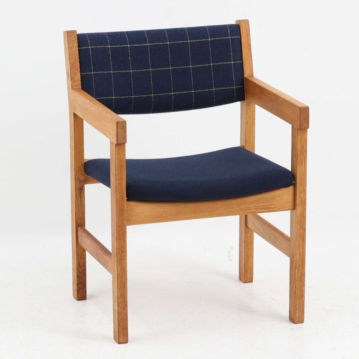 Hans J. Wegner（ハンス・J・ウェグナー）がデザインし、Getama（ゲタマ）が製造を手掛けたGE151アームチェアです。オーク材による直線的で端正なフレームに、ゆるやかにカーブした背もたれと座面を組み合わせた、軽快で機能的な佇まいが魅力。幅のあるアームは木の質感を存分に感じられ、長年の使用による風合いもビンテージならではの味わいです。ダイニングや書斎のほか、ゆったりと腰掛けるラウンジチェアとしても取り入れやすい一脚です。