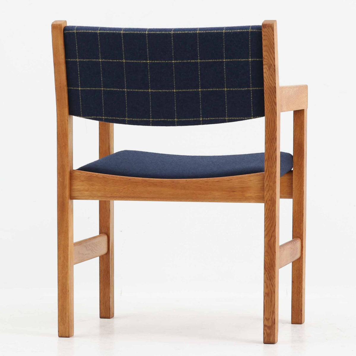 Hans J. Wegner（ハンス・J・ウェグナー）がデザインし、Getama（ゲタマ）が製造を手掛けたGE151アームチェアです。オーク材による直線的で端正なフレームに、ゆるやかにカーブした背もたれと座面を組み合わせた、軽快で機能的な佇まいが魅力。幅のあるアームは木の質感を存分に感じられ、長年の使用による風合いもビンテージならではの味わいです。ダイニングや書斎のほか、ゆったりと腰掛けるラウンジチェアとしても取り入れやすい一脚です。
