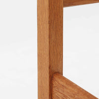 Hans J. Wegner（ハンス・J・ウェグナー）がデザインし、Getama（ゲタマ）が製造を手掛けたGE151アームチェアです。オーク材による直線的で端正なフレームに、ゆるやかにカーブした背もたれと座面を組み合わせた、軽快で機能的な佇まいが魅力。幅のあるアームは木の質感を存分に感じられ、長年の使用による風合いもビンテージならではの味わいです。ダイニングや書斎のほか、ゆったりと腰掛けるラウンジチェアとしても取り入れやすい一脚です。