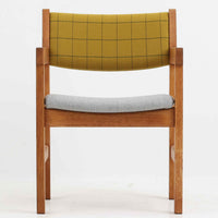 Hans J. Wegner（ハンス・J・ウェグナー）がデザインし、Getama（ゲタマ）が製造を手掛けたGE151アームチェアです。オーク材による直線的で端正なフレームに、ゆるやかにカーブした背もたれと座面を組み合わせた、軽快で機能的な佇まいが魅力。幅のあるアームは木の質感を存分に感じられ、長年の使用による風合いもビンテージならではの味わいです。ダイニングや書斎のほか、ゆったりと腰掛けるラウンジチェアとしても取り入れやすい一脚です。