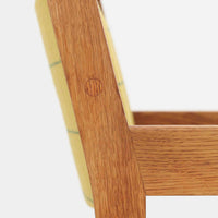 Hans J. Wegner（ハンス・J・ウェグナー）がデザインし、Getama（ゲタマ）が製造を手掛けたGE151アームチェアです。オーク材による直線的で端正なフレームに、ゆるやかにカーブした背もたれと座面を組み合わせた、軽快で機能的な佇まいが魅力。幅のあるアームは木の質感を存分に感じられ、長年の使用による風合いもビンテージならではの味わいです。ダイニングや書斎のほか、ゆったりと腰掛けるラウンジチェアとしても取り入れやすい一脚です。