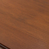 Ejner Larsen & Aksel Bender Madsenが手掛け、Naestved Mobelfabrikで製作されたエクステンションダイニングテーブルは、チーク材の天板とオーク材の脚部を組み合わせた北欧ビンテージらしい上質な佇まいが魅力です。直線的で端正なフォルムの中に、天板縁の丁寧な面取りや幕板の滑らかな造形など、当時の高い職人技が随所に感じられます。幅120cmから最大230cmまで伸長可能な構造により、日常使いから来客時まで柔軟に対応でき、空間や人数に合わせた使い方が可能です。経年変化によって深みを増した木肌の表情が、長く愛用されてきたビンテージならではの存在感を放ち、ダイニングの主役として落ち着きと品格を添えてくれる一台です。脚先には床へのダメージや汚れを防ぐためにチーク材がジョイントされており、実用性を考慮した当時の設計思想がうかがえます。また、裏面には「SKM」の刻印が確認でき、スウェーデン軍（Svenska KrigsMakten）の備品として使用されていたことを示す、背景のある希少な個体です。