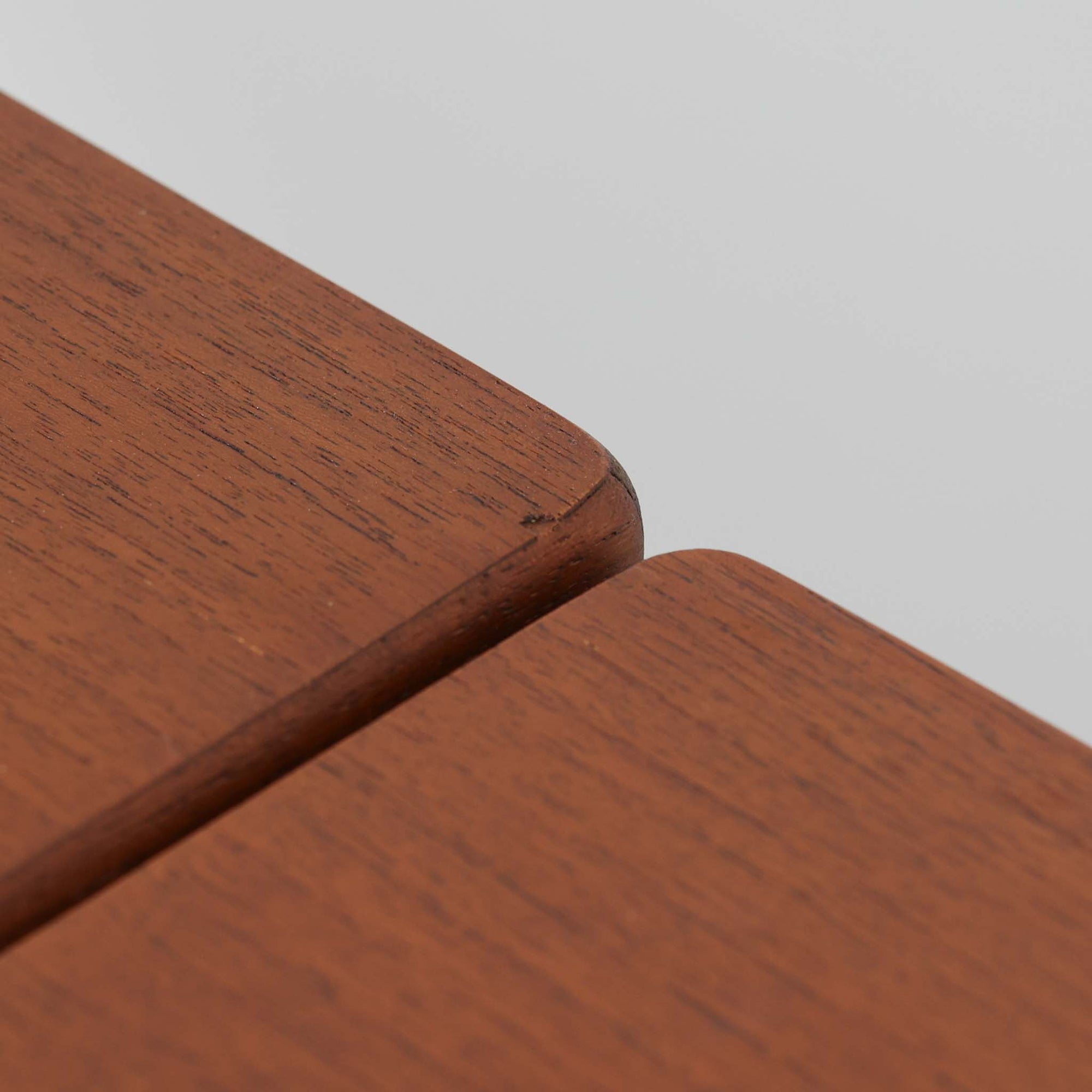 Ejner Larsen &amp; Aksel Bender Madsenが手掛け、Naestved Mobelfabrikで製作されたエクステンションダイニングテーブルは、チーク材の天板とオーク材の脚部を組み合わせた北欧ビンテージらしい上質な佇まいが魅力です。直線的で端正なフォルムの中に、天板縁の丁寧な面取りや幕板の滑らかな造形など、当時の高い職人技が随所に感じられます。幅120cmから最大230cmまで伸長可能な構造により、日常使いから来客時まで柔軟に対応でき、空間や人数に合わせた使い方が可能です。経年変化によって深みを増した木肌の表情が、長く愛用されてきたビンテージならではの存在感を放ち、ダイニングの主役として落ち着きと品格を添えてくれる一台です。脚先には床へのダメージや汚れを防ぐためにチーク材がジョイントされており、実用性を考慮した当時の設計思想がうかがえます。また、裏面には「SKM」の刻印が確認でき、スウェーデン軍（Svenska KrigsMakten）の備品として使用されていたことを示す、背景のある希少な個体です。