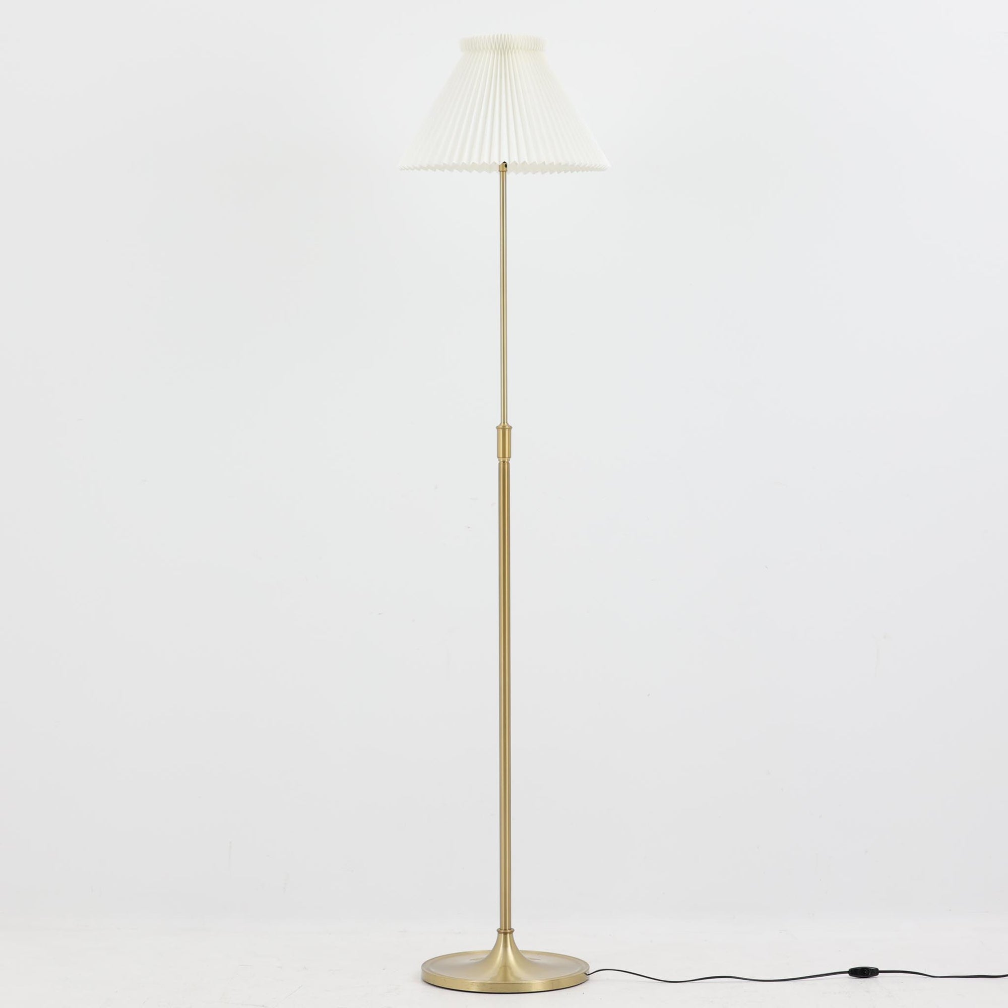 Aage PetersenによるデザインでLe Klint社から発表されたフロアランプModel 339です。真鍮をふんだんに使用したスタンドは高さ132～178cmまで調整可能で、空間や用途に合わせて最適な明かりを提供します。すっきりとした円形ベースと、ハンドメイドのプリーツシェードが北欧デザインらしい上質な雰囲気を演出。真鍮ならではの高級感に加え、経年による自然な風合いが味わいを増し、ビンテージらしい魅力を存分に堪能できます。リビングや書斎の読書灯としてはもちろん、間接照明としても活躍する存在感ある一品です。