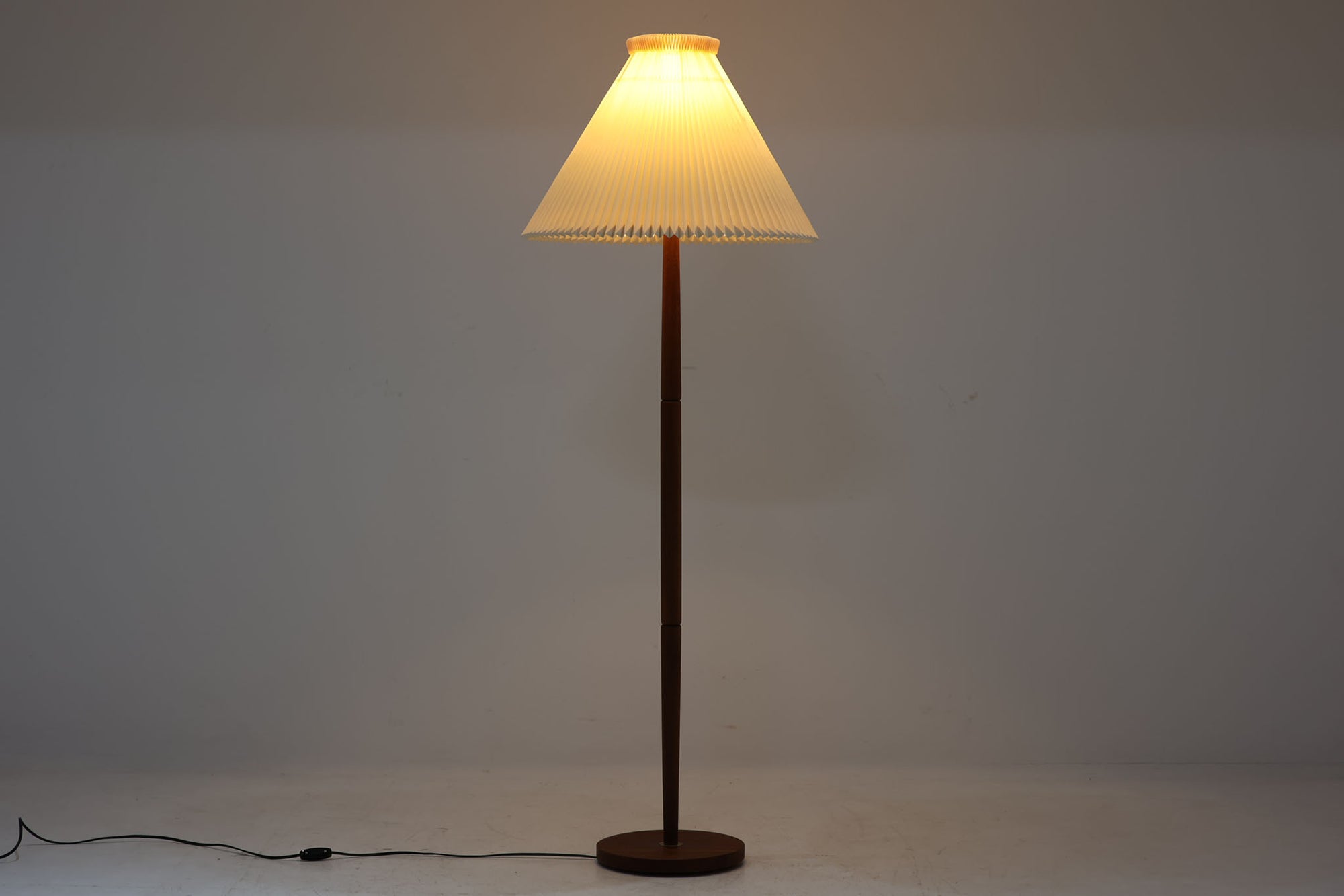 北欧より買い付けたフロアランプです。フレームには高品質なチーク材が使用されており、温かみのある木肌と洗練されたデザインが、北欧照明ならではの魅力を存分に感じさせます。付属のシェードは、デンマークの名門ブランドLE KLINT社製。使用感はございますが、職人の手折りによる独特のデザインが、柔らかく美しい光を生み出し、空間全体を優しく包み込みます。リビングや読書スペース、ベッドサイドなど様々な場所でお使いいただけます。