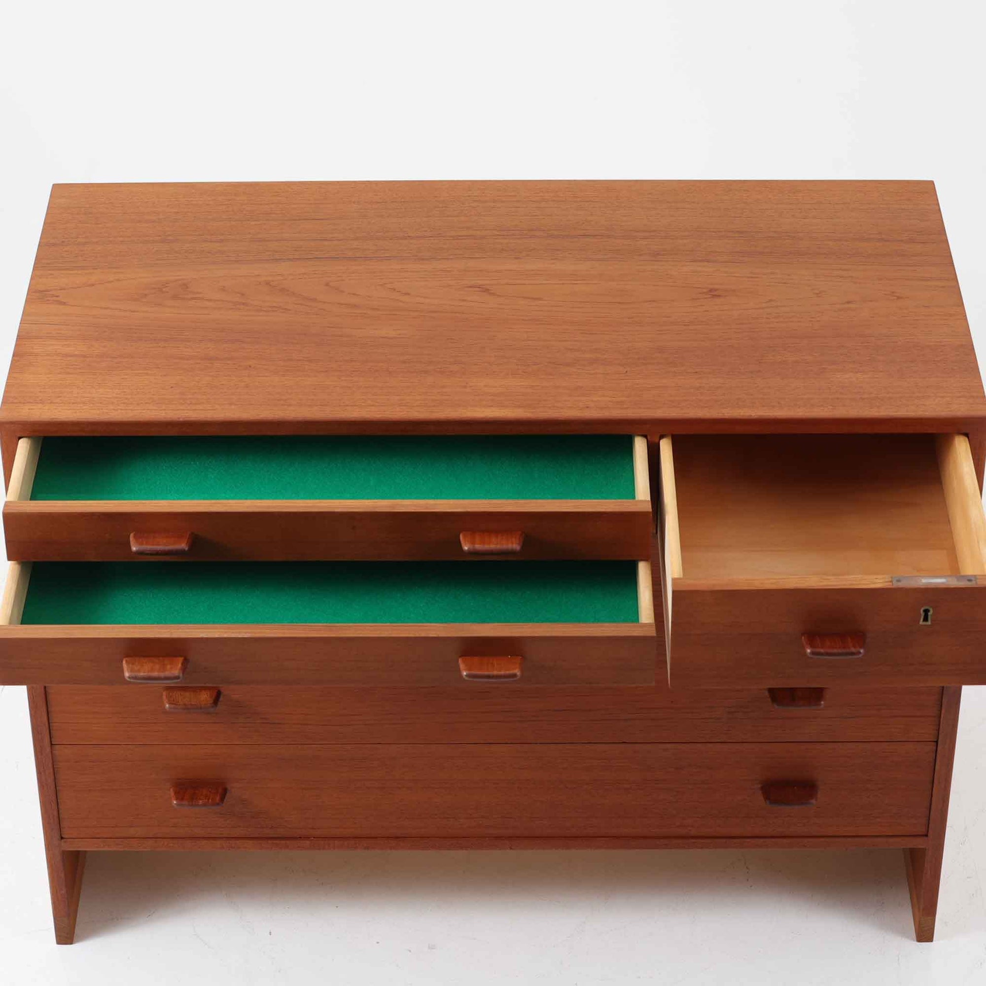 Hans J. Wegnerが手掛けたこちらの多段チェストは、Ry Mobler社によって1962年に製造されたもので、チーク材とオーク材の美しいコントラストが印象的な一台です。チーク材仕様のモデルは現存数が少なく、希少です。端正なフォルムと落ち着いた木肌は、寝室やリビングに上質な温もりをもたらします。引き出し内部にはフェルトが敷かれ、最上段には鍵付きの収納も備わっており、細部にまでこだわった設計が魅力です。※写真には写っておりませんが、鍵が1点付属いたします。実用性と美しさを兼ね備えた、北欧ビンテージらしい逸品です。