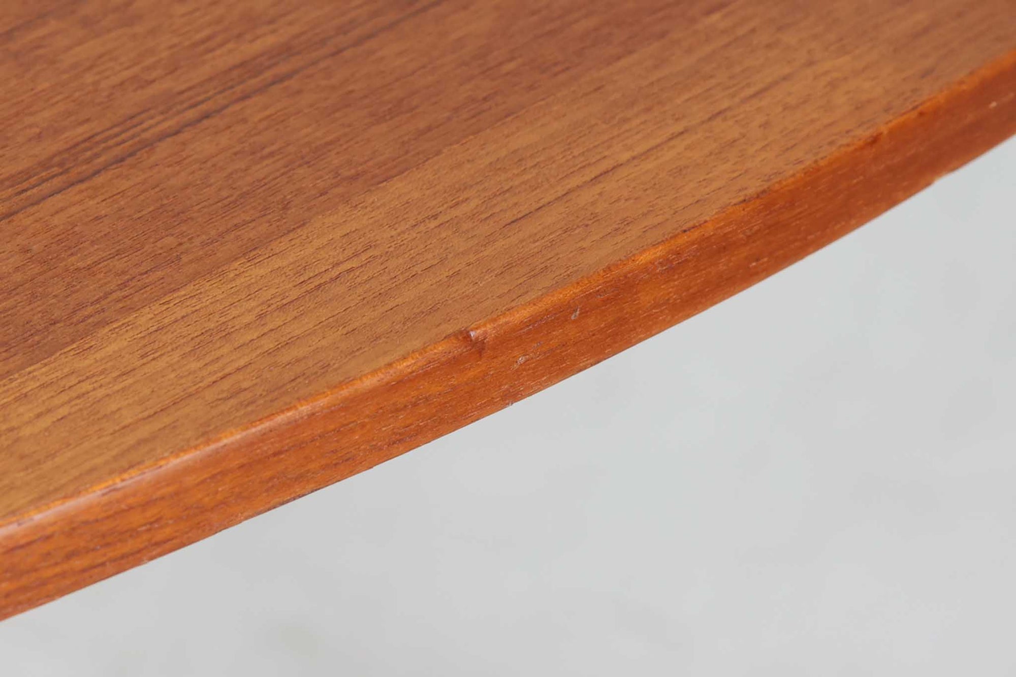 こちらはスウェーデンで買い付けたエクステンションダイニングテーブルです。天板は、珍しいラウンドスクエアの形状を採用しており、柔らかな印象と洗練されたデザインが魅力です。脚部は左右に開く構造で安定感があり、幕板は中央部分に向かってカットされているため、椅子の出し入れや座り心地にも配慮されています。また、来客時には付属の拡張板を使用することで、天板を簡単に広げられ、大人数での食事にも対応可能です。使い手の利便性を追求した設計が光る一品です。素材には、良質なチーク材とオーク材を使用しており、木目の美しさや温かみを感じられます。北欧家具ならではの高いデザイン性と実用性を兼ね備えたダイニングテーブルをぜひお楽しみください。