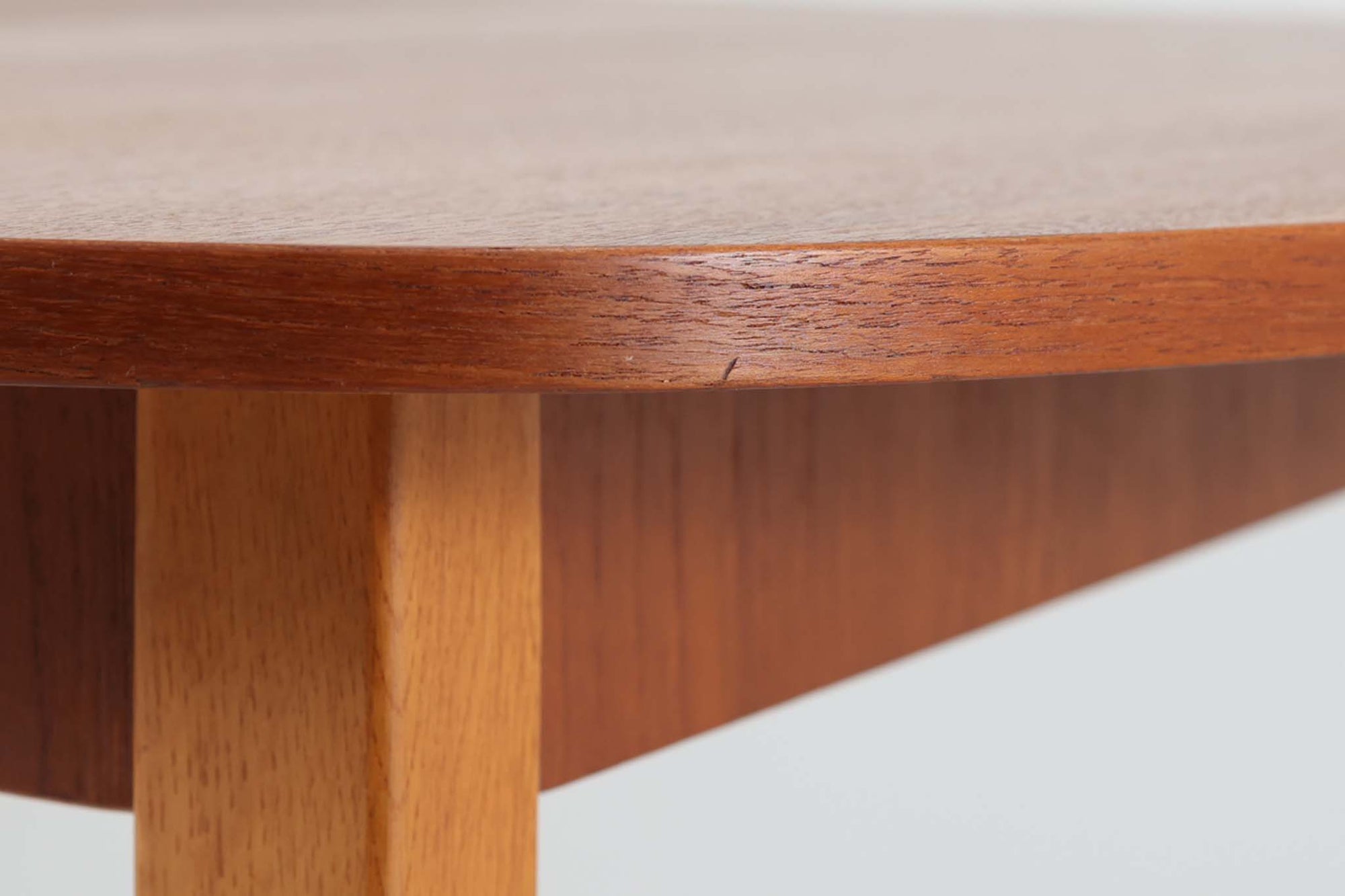 こちらはスウェーデンで買い付けたエクステンションダイニングテーブルです。天板は、珍しいラウンドスクエアの形状を採用しており、柔らかな印象と洗練されたデザインが魅力です。脚部は左右に開く構造で安定感があり、幕板は中央部分に向かってカットされているため、椅子の出し入れや座り心地にも配慮されています。また、来客時には付属の拡張板を使用することで、天板を簡単に広げられ、大人数での食事にも対応可能です。使い手の利便性を追求した設計が光る一品です。素材には、良質なチーク材とオーク材を使用しており、木目の美しさや温かみを感じられます。北欧家具ならではの高いデザイン性と実用性を兼ね備えたダイニングテーブルをぜひお楽しみください。