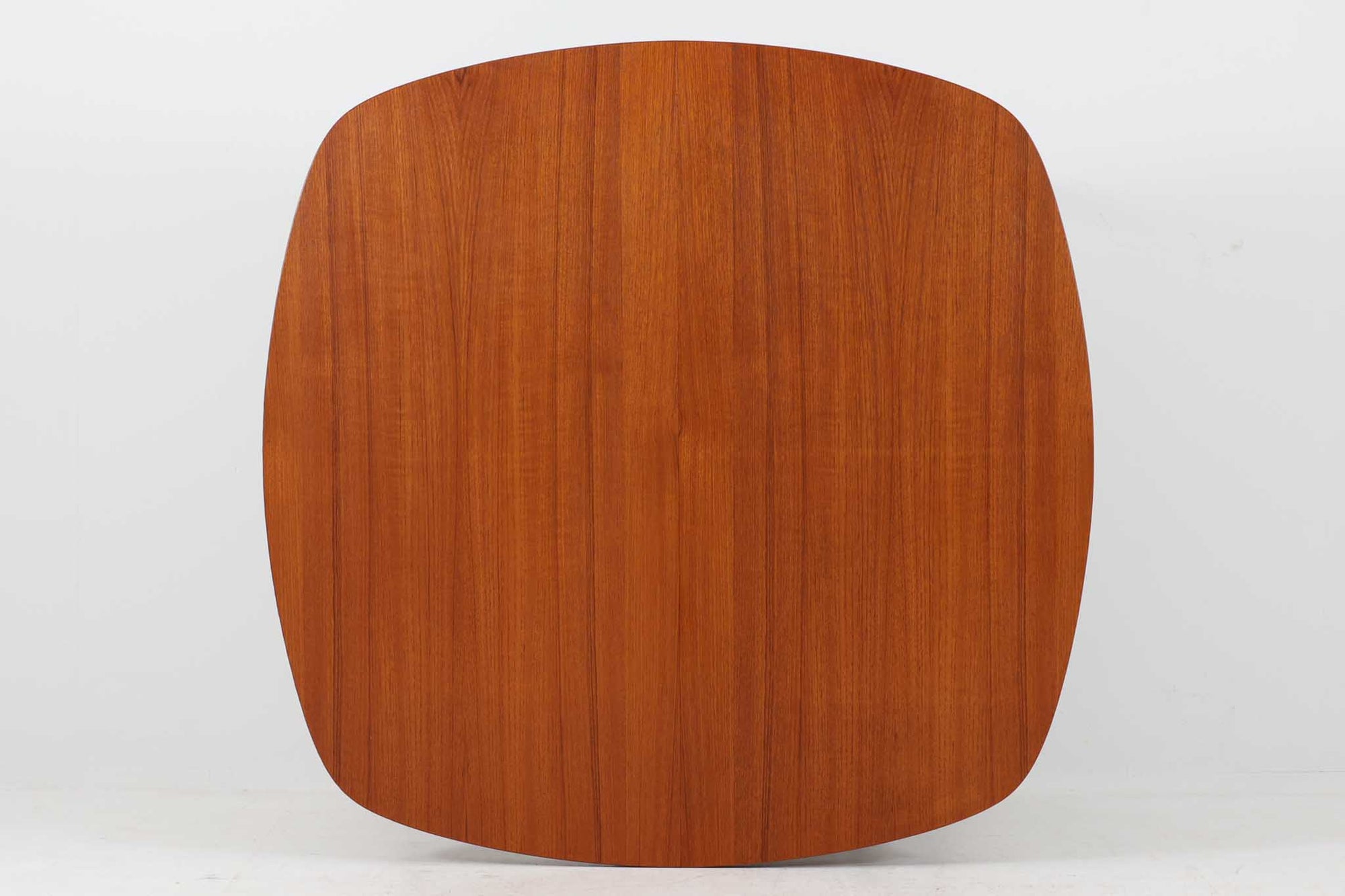 こちらはスウェーデンで買い付けたエクステンションダイニングテーブルです。天板は、珍しいラウンドスクエアの形状を採用しており、柔らかな印象と洗練されたデザインが魅力です。脚部は左右に開く構造で安定感があり、幕板は中央部分に向かってカットされているため、椅子の出し入れや座り心地にも配慮されています。また、来客時には付属の拡張板を使用することで、天板を簡単に広げられ、大人数での食事にも対応可能です。使い手の利便性を追求した設計が光る一品です。素材には、良質なチーク材とオーク材を使用しており、木目の美しさや温かみを感じられます。北欧家具ならではの高いデザイン性と実用性を兼ね備えたダイニングテーブルをぜひお楽しみください。