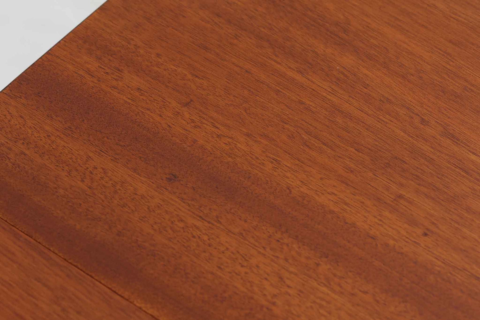 こちらはスウェーデンで買い付けたエクステンションダイニングテーブルです。天板は、珍しいラウンドスクエアの形状を採用しており、柔らかな印象と洗練されたデザインが魅力です。脚部は左右に開く構造で安定感があり、幕板は中央部分に向かってカットされているため、椅子の出し入れや座り心地にも配慮されています。また、来客時には付属の拡張板を使用することで、天板を簡単に広げられ、大人数での食事にも対応可能です。使い手の利便性を追求した設計が光る一品です。素材には、良質なチーク材とオーク材を使用しており、木目の美しさや温かみを感じられます。北欧家具ならではの高いデザイン性と実用性を兼ね備えたダイニングテーブルをぜひお楽しみください。