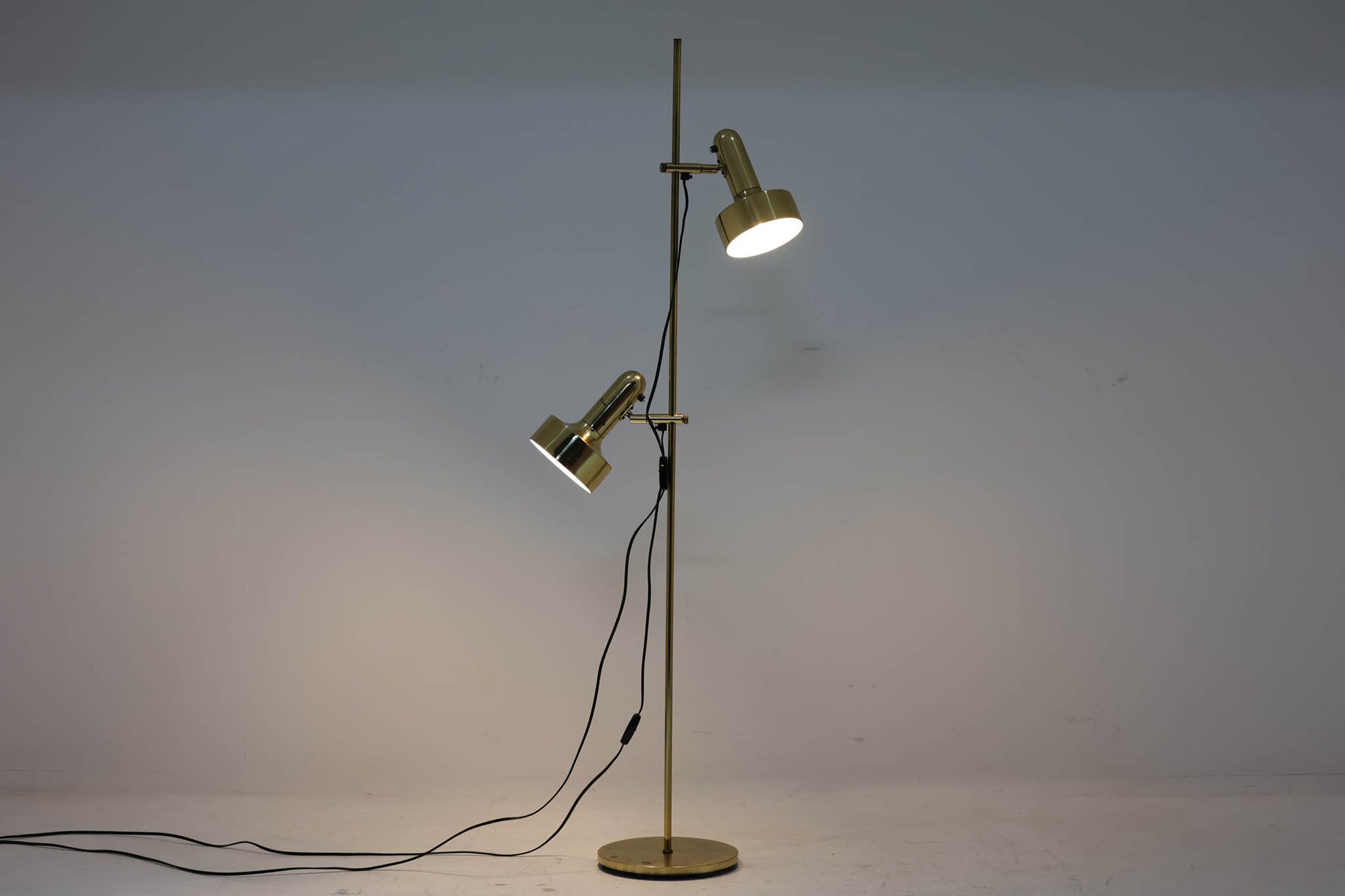 デンマークの照明ブランド「TS Belysning」によるゴールド仕上げのエレガントなフロアランプです。高さと角度を調整できる2つのシェードが特徴で、手元を明るく照らしたり空間全体に光を広げたりと、用途に応じたライティングが可能です。細身のゴールドフレームは上品で、使い込まれた錆や経年変化が味わいとなり、独特の風合いを楽しめます。北欧らしい洗練された雰囲気で、リビングや書斎に最適なデザイン性と実用性を兼ね備えた一品です。