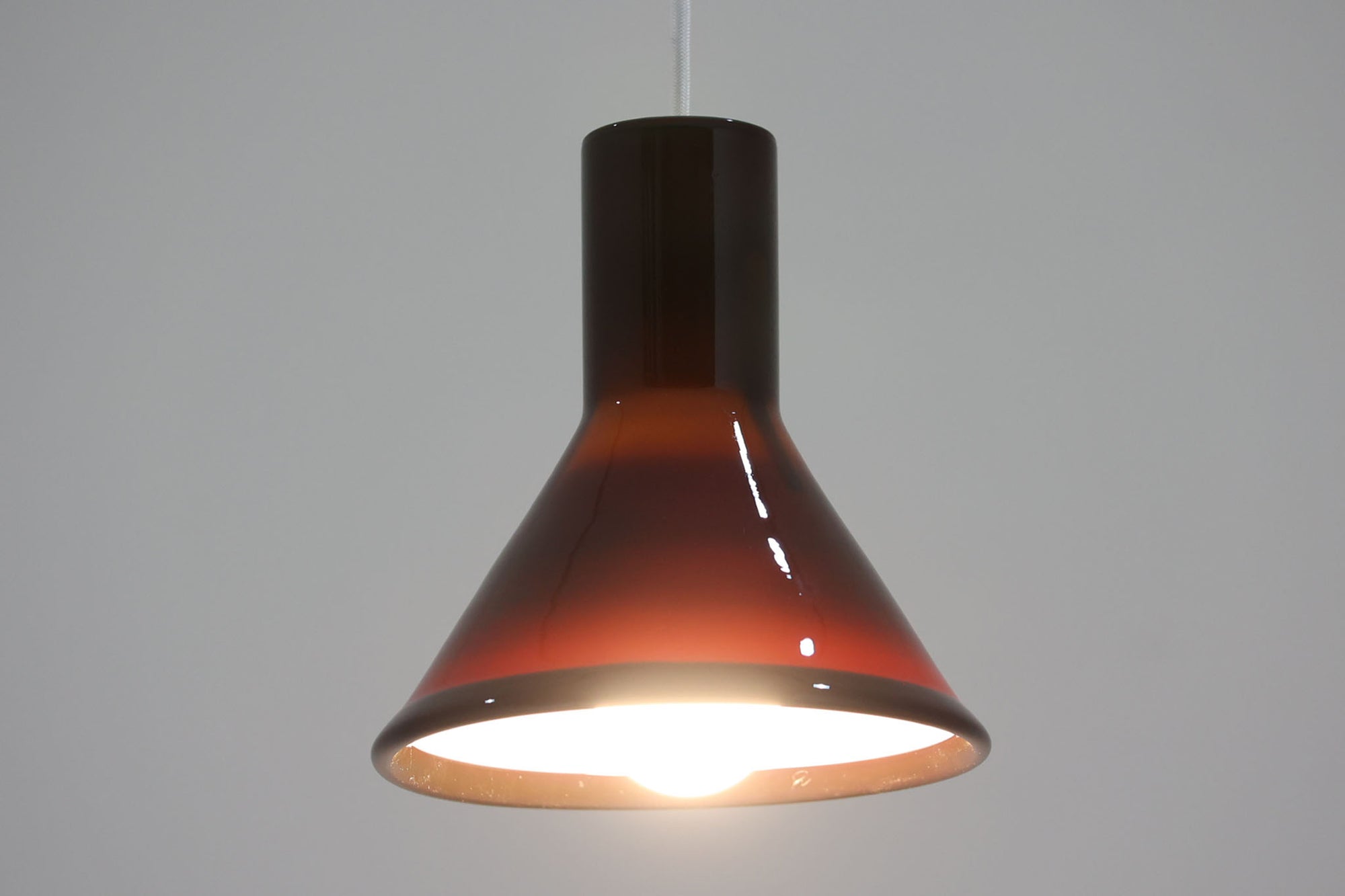 北欧より買い付けた、Holmgaard社製ビンテージランプです。照明部分はデンマークを代表する照明メーカーFog &amp; morup社によって作成されています。Holmgaard社の人気シリーズである「P&amp;T PENDEL」は、内側と外側の2層の色味が特徴的です。これにより、消灯時と点灯時で異なる表情を楽しむことができます。美しいデザインとともに、照明効果もお楽しみいただける素晴らしいアイテムです。