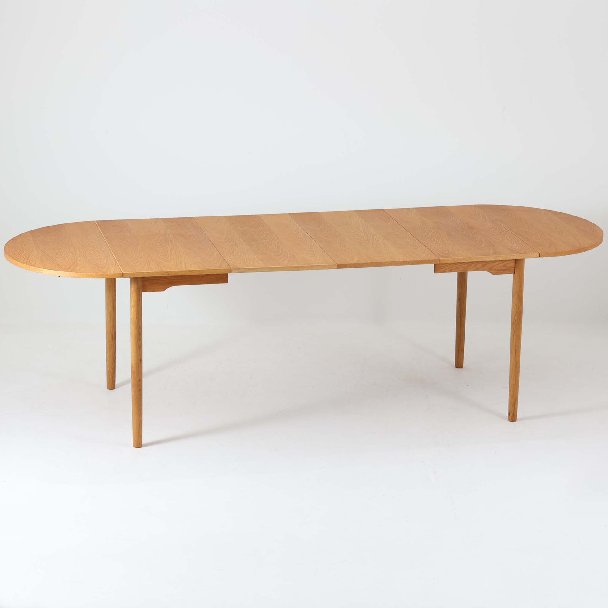 オーク材の美しい木目が際立つこちらのエクステンションテーブルは、バタフライ式の天板を採用しており、必要に応じて両サイドを拡張できる機能的な構造が魅力です。無駄のないシンプルなフォルムと優しい木肌は、北欧ビンテージ家具ならではの落ち着いた雰囲気を醸し出しており、空間に温もりを添えてくれます。使わないときはコンパクトにたたんでおけるため、限られたスペースでも取り入れやすく、実用性と美しさを兼ね備えた一台です。