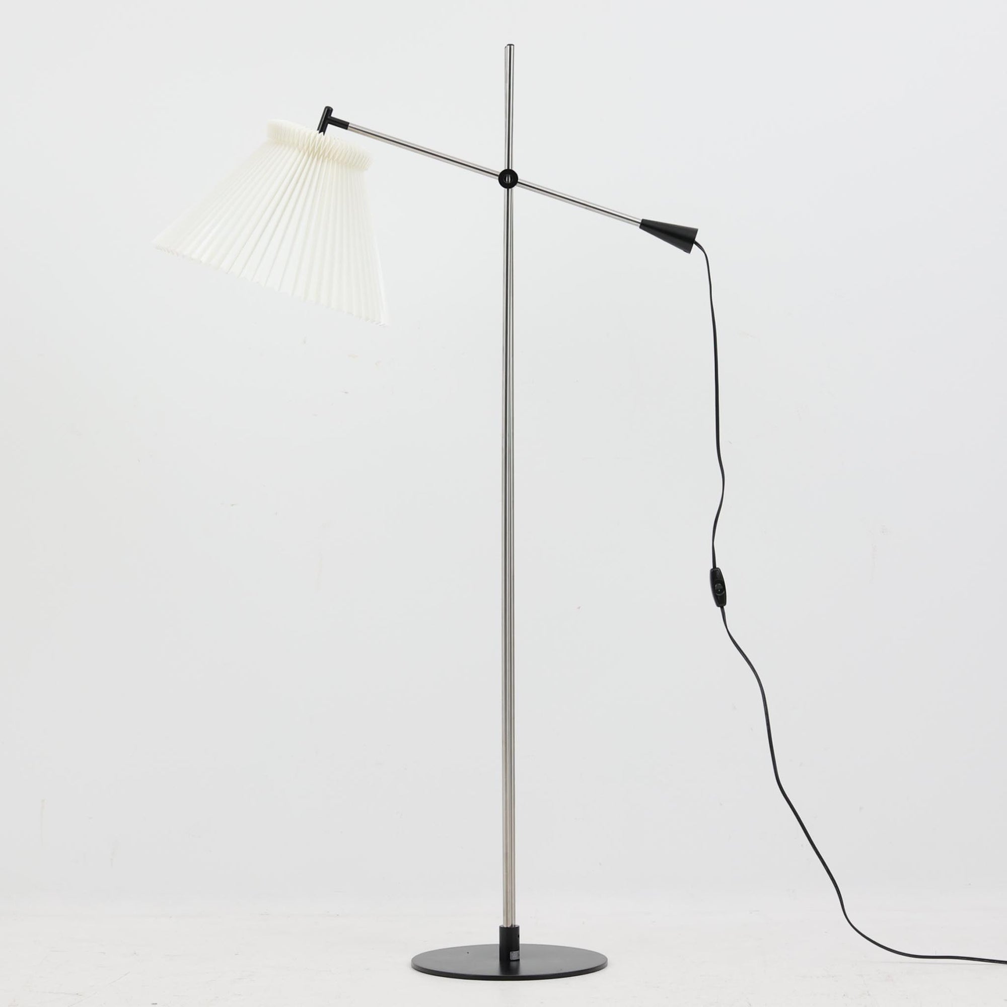 Christian Hvidtによってデザインされ、Le Klint社から発表されたフロアランプModel 323です。スチール製のシャープなフレームに、手作業で折り込まれたプリーツシェードを組み合わせた構成が特徴で、北欧デザインらしいシンプルかつ機能的な美しさを備えています。高さ135cmのバランスの良いサイズ感で、リビングや書斎に柔らかな光を届けます。角度調整可能なアームは使い勝手に優れ、読書灯や間接照明としても重宝するビンテージ品です。